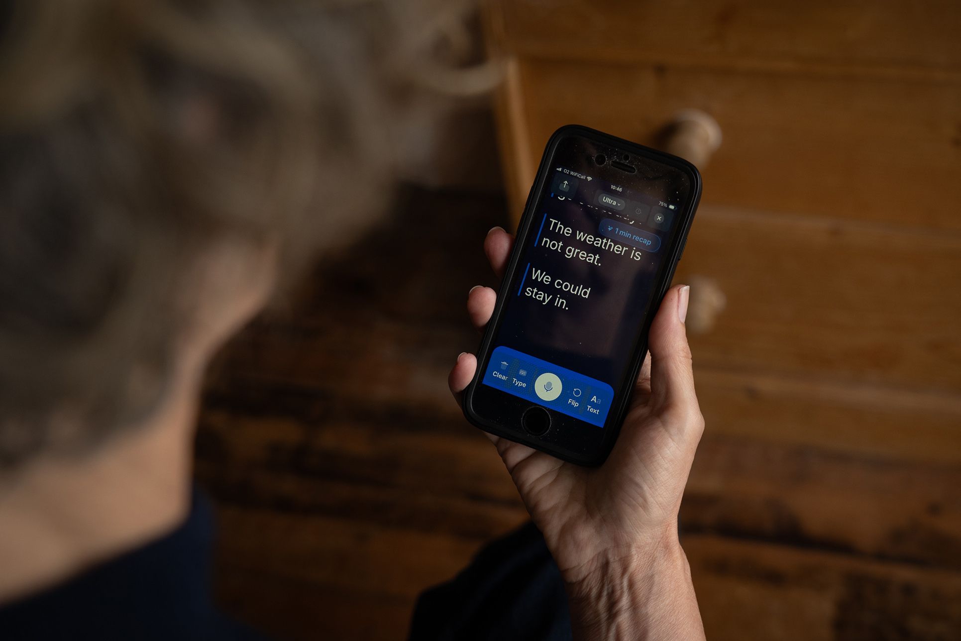 A person holding a phone displaying text: “The weather is not great. We could stay in.”