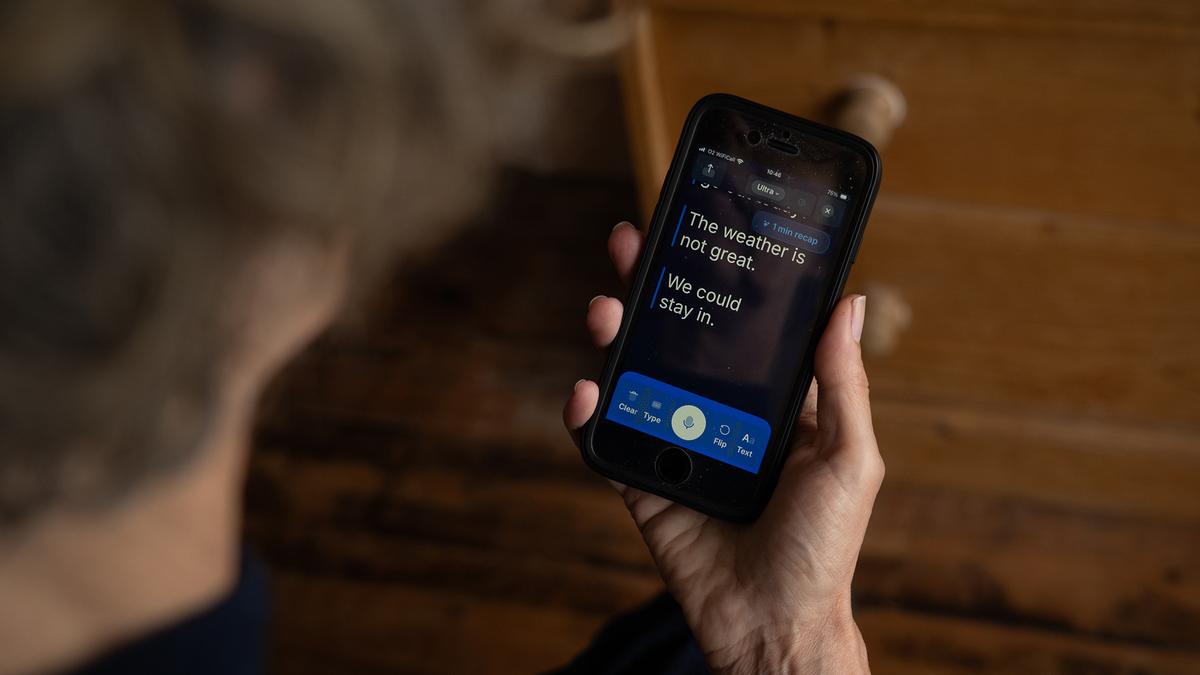 A person holding a phone displaying text: “The weather is not great. We could stay in.”