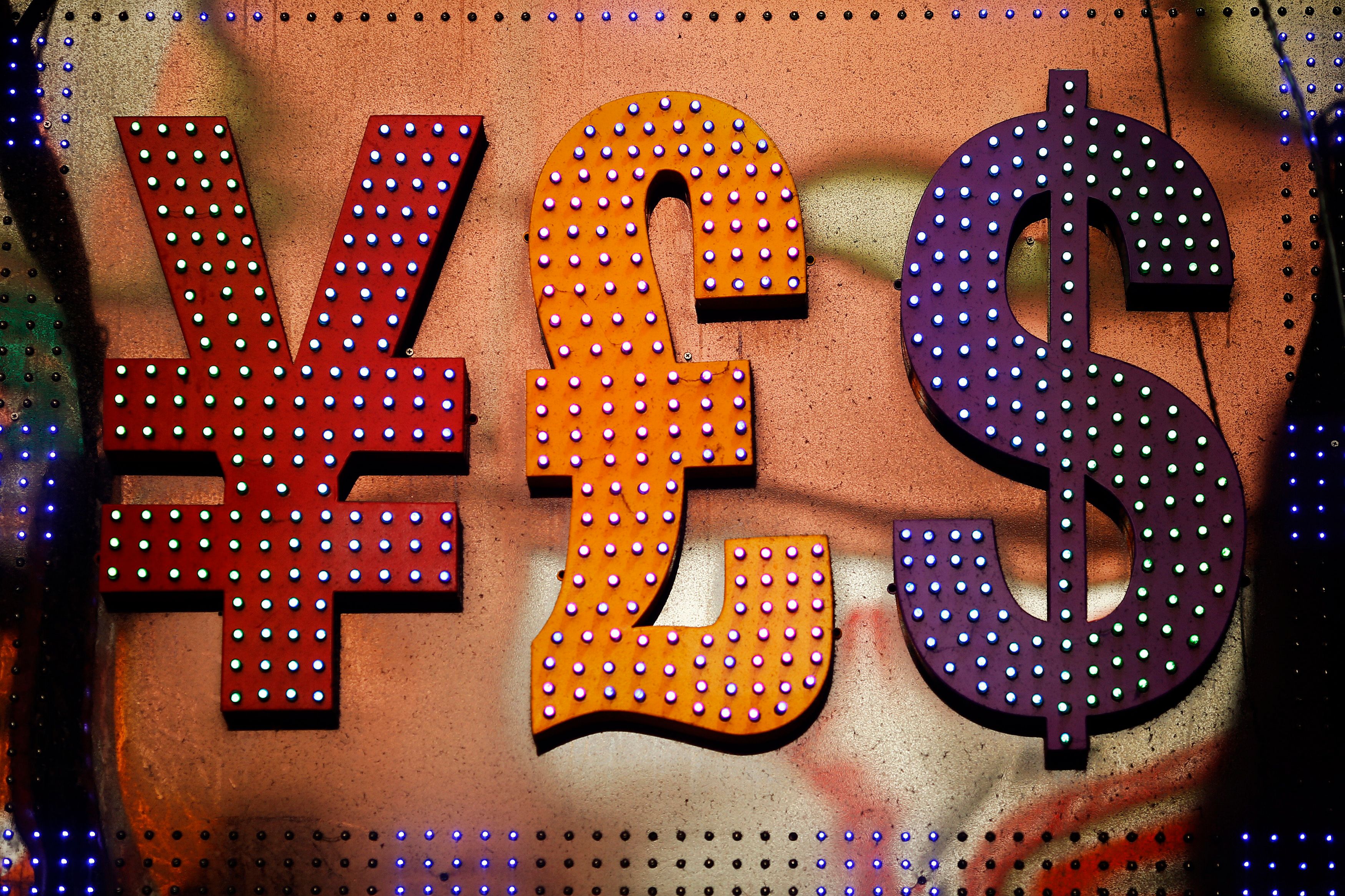 Illuminated currency symbols yen, pound and dollar in red, orange and purple on a textured background.