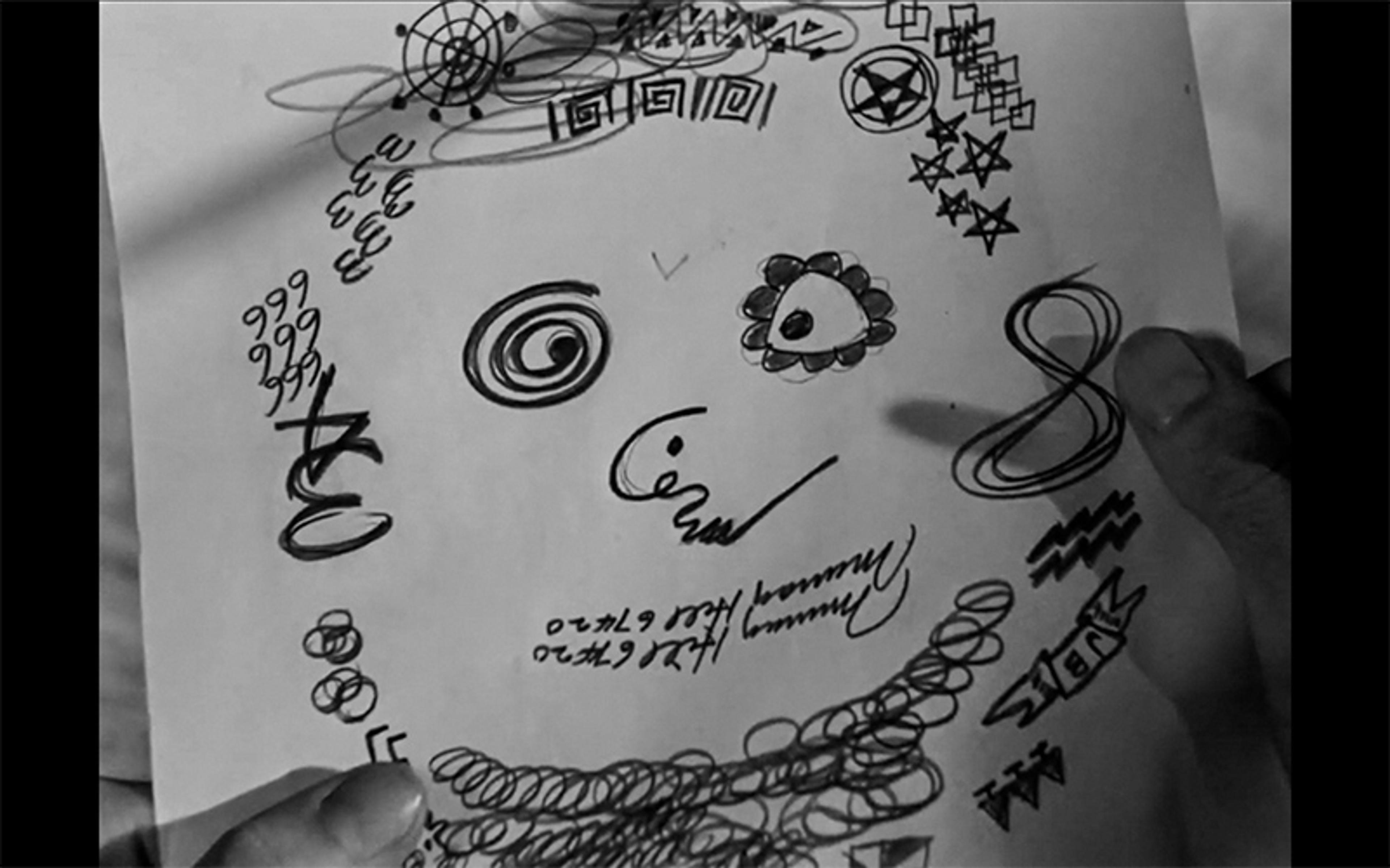 Black and white photo of a hand holding a page filled with abstract doodles and geometric shapes.