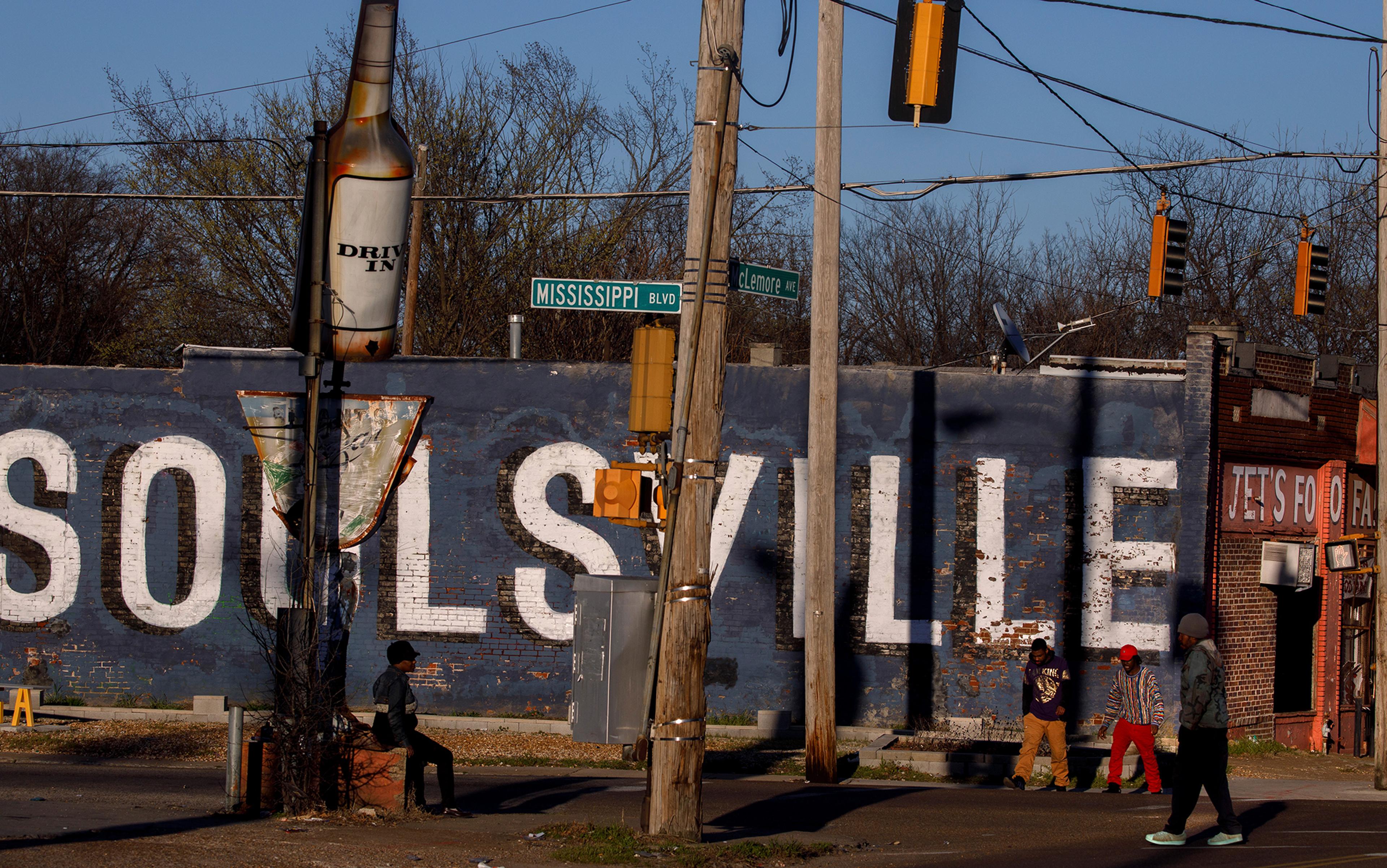 A street intersection; a wall is painted with the word Soulsville in large letters with peeling paint