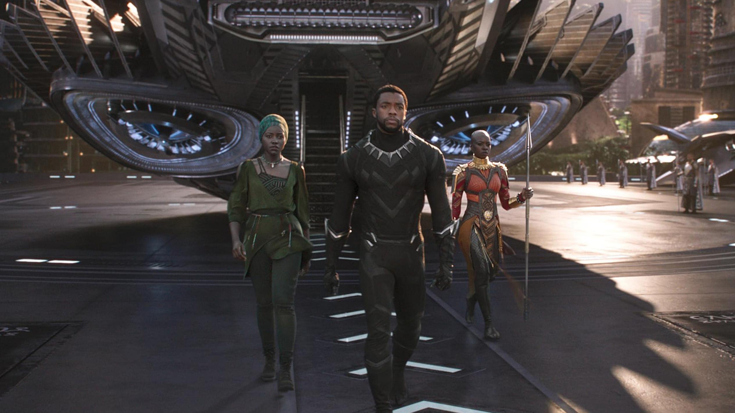 Scene from a film with three characters walking from a futuristic spacecraft in a city setting.