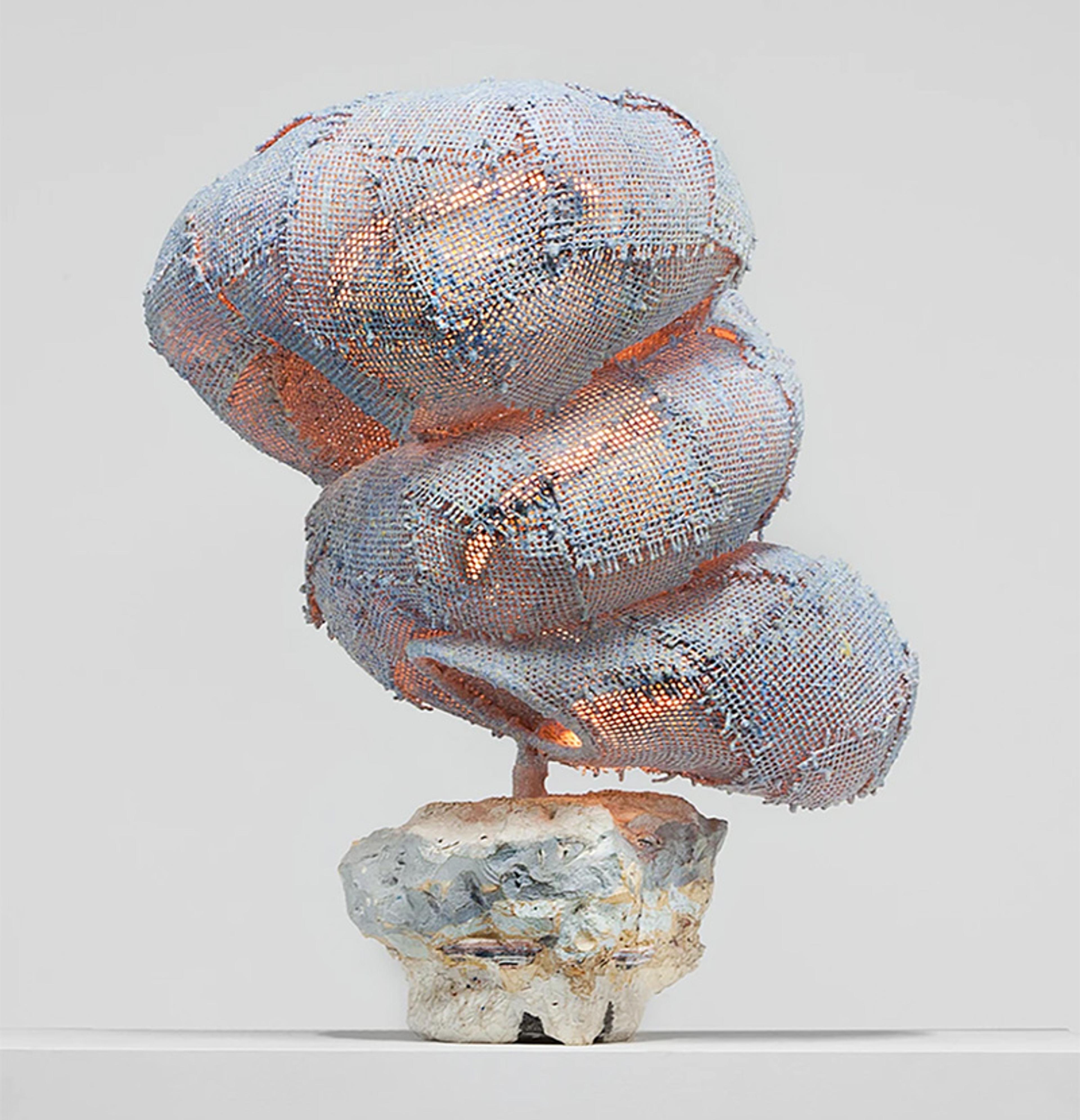 Sculpture of an abstract, coiled form covered in woven material with muted colours, mounted on a textured, stone-like base.