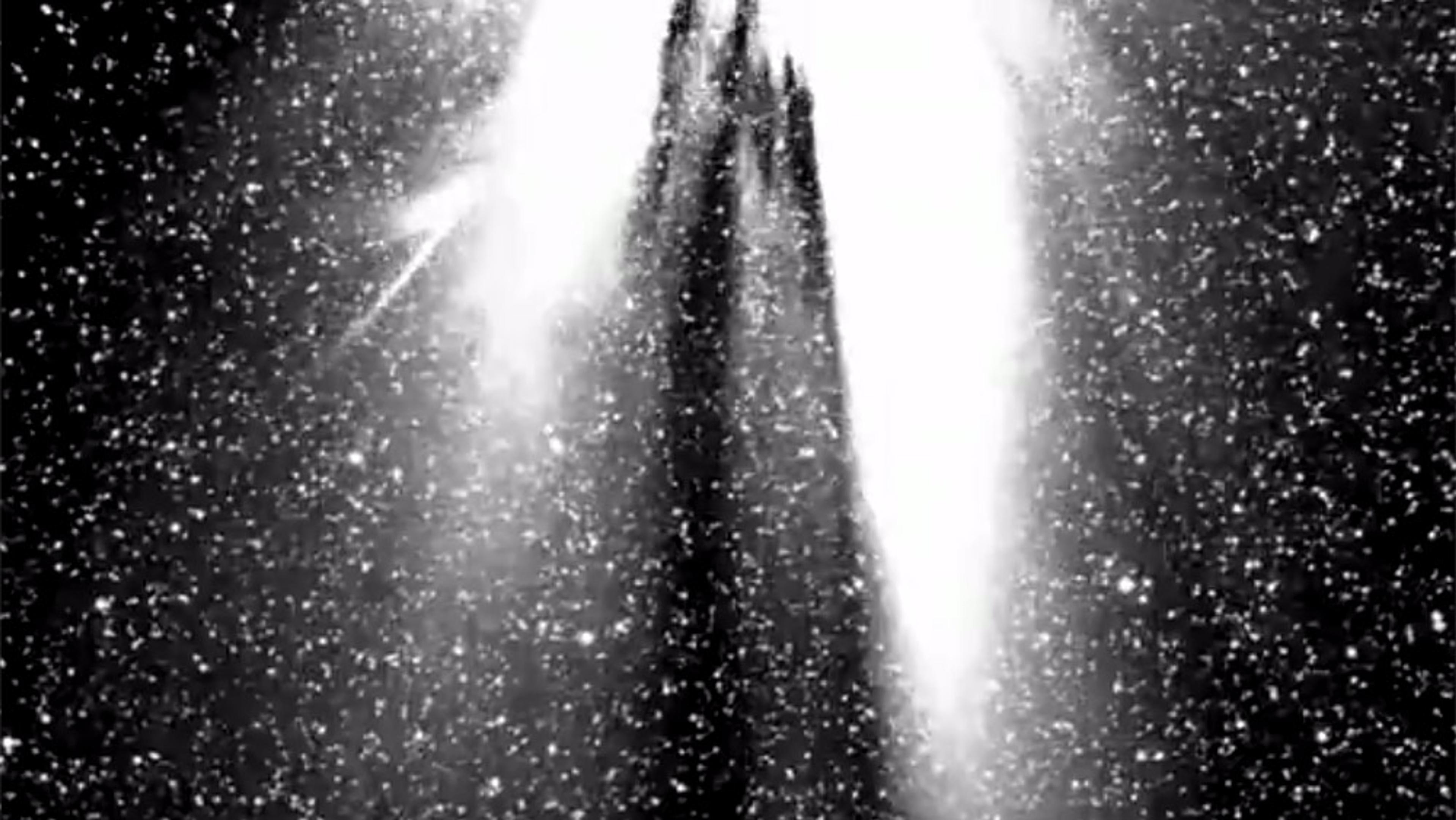 A dark sky with numerous stars and a bright, luminous object emitting light in the centre.