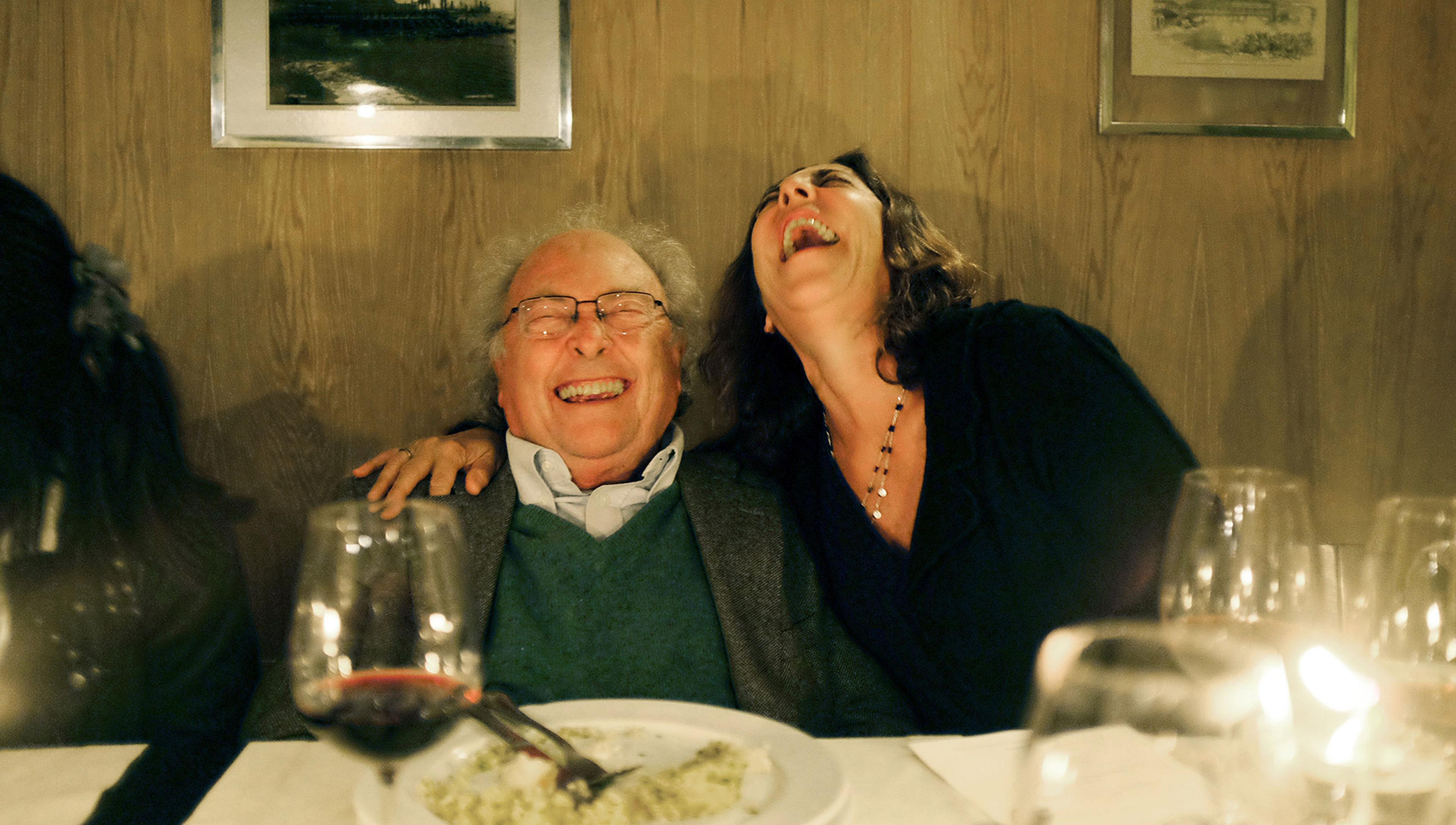 A man and a woman laughing together in a restaurant