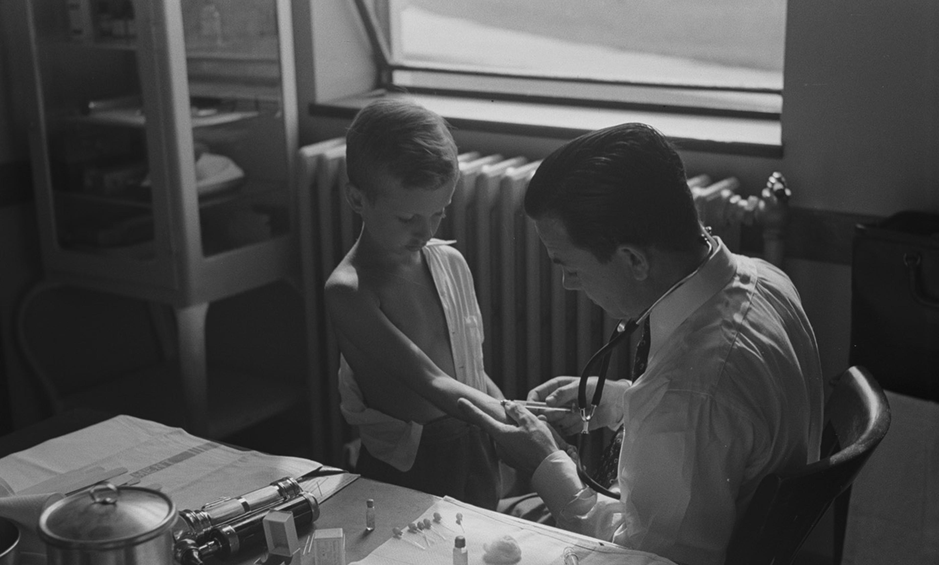 <p>Doctor examining child at preschool clinic. Greenbelt, Maryland in 1938. <em>Photo by Marion Post Wolcott/FSA/Library of Congress</em></p>