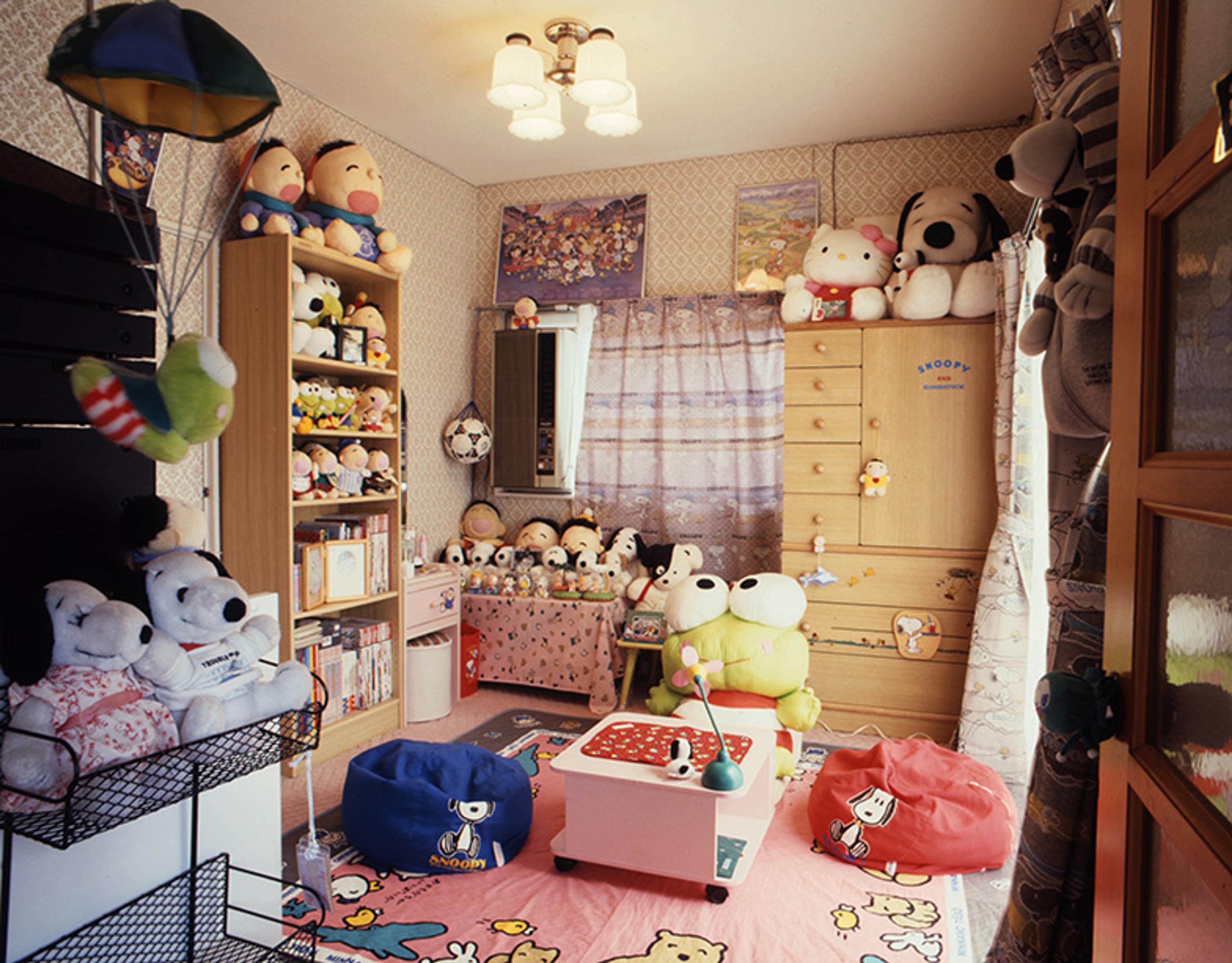 A child’s colourful bedroom featuring shelves filled with stuffed toys.