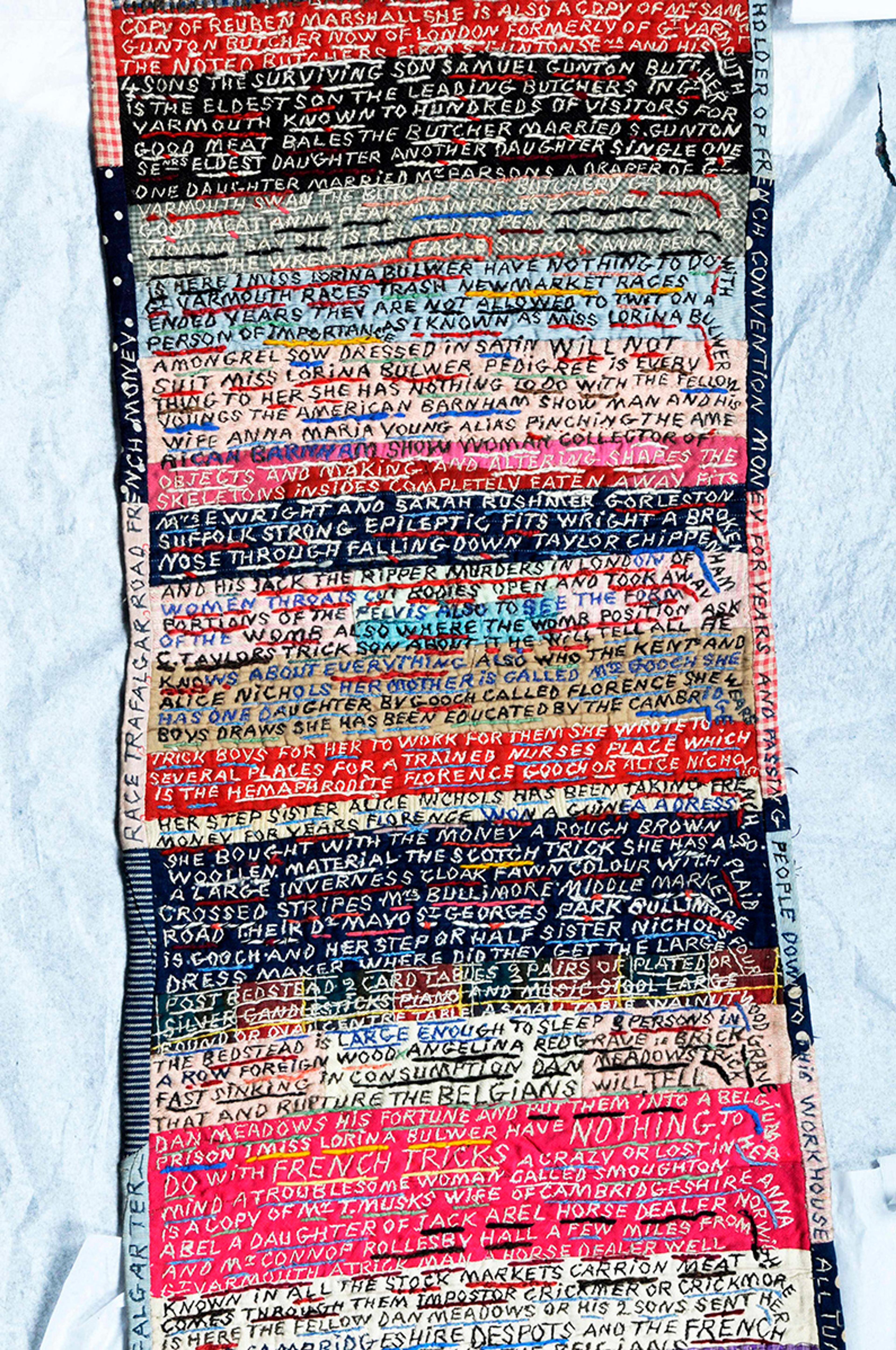 Hand-embroidered textile with dense text in various colours.
