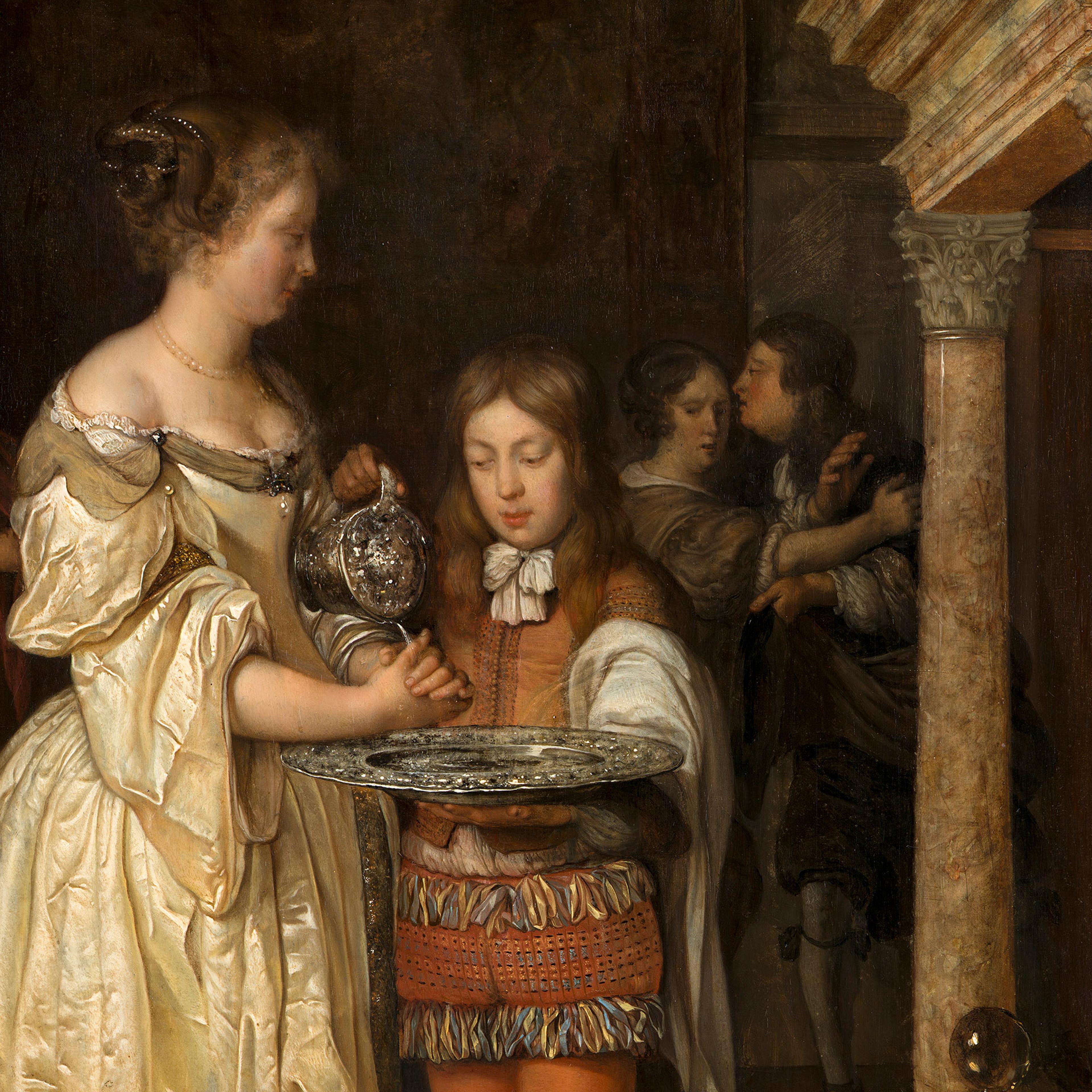 Woman in historical dress washing her hands with water poured by a child from a jug, with onlookers in an ornate interior setting.