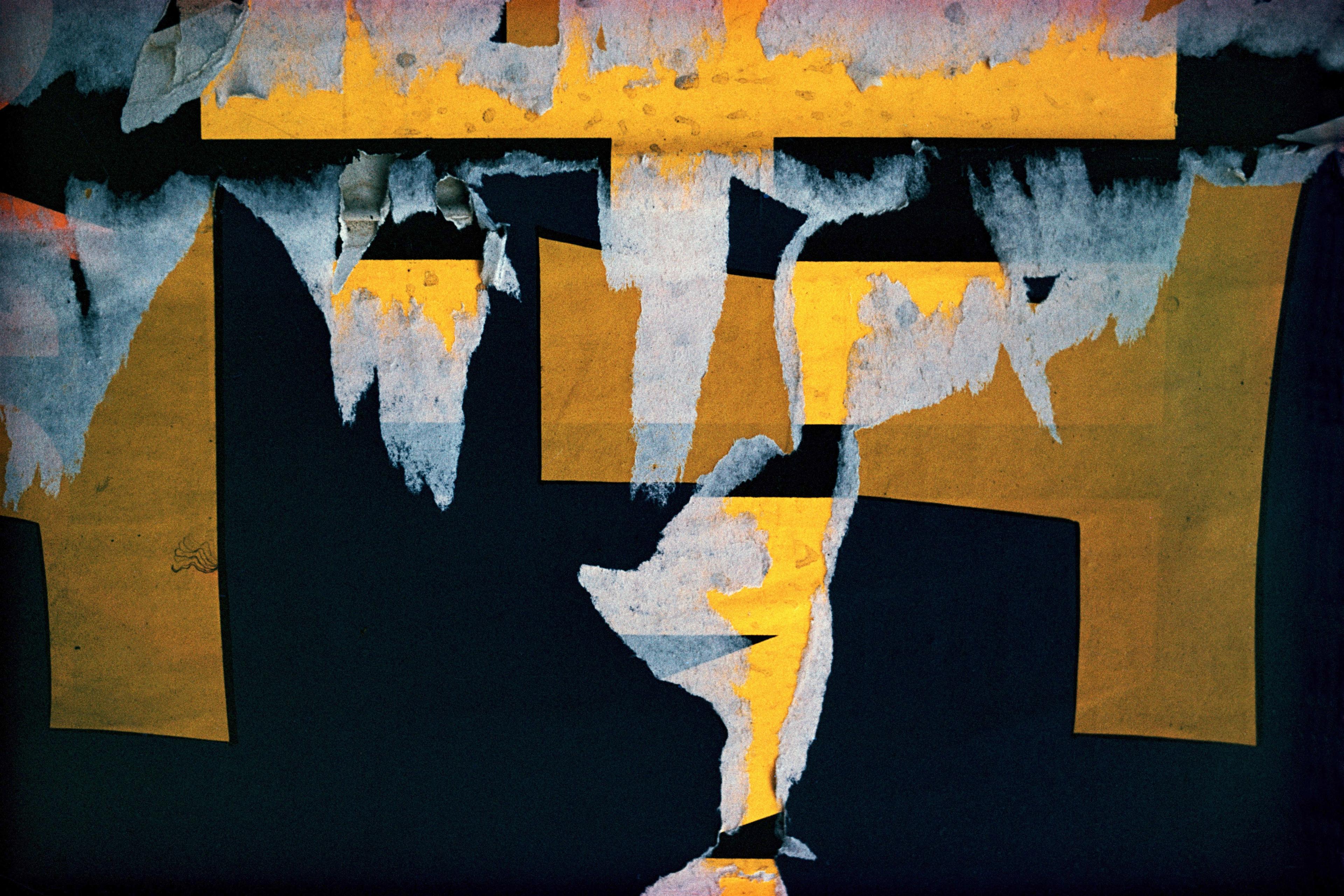 Abstract painting with torn paper layers in orange, blue and black, creating textured geometric shapes and contrasts.