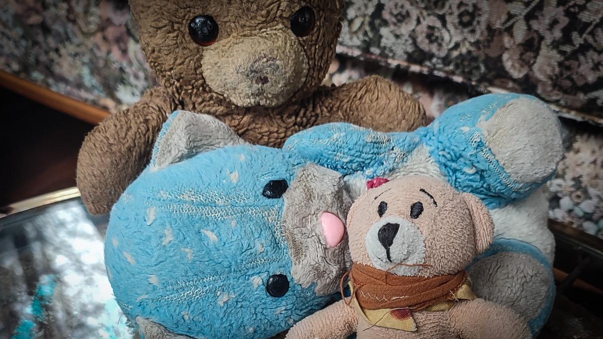 Three worn teddy bears, one beige, one blue and a brown one that has had its nose rubbed off.