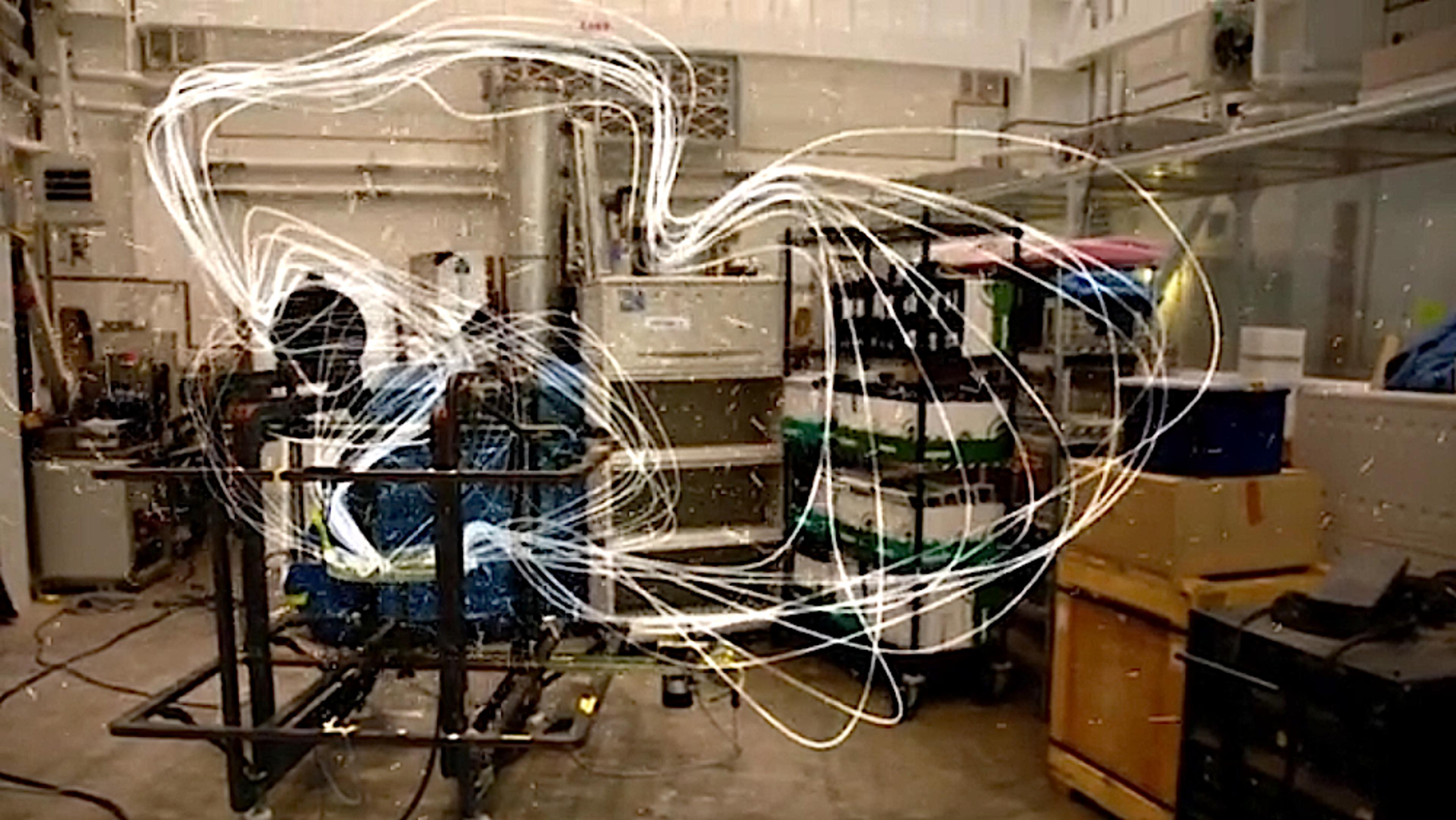 A laboratory with equipment and a swirling pattern of light trails in the foreground, suggesting movement or energy.