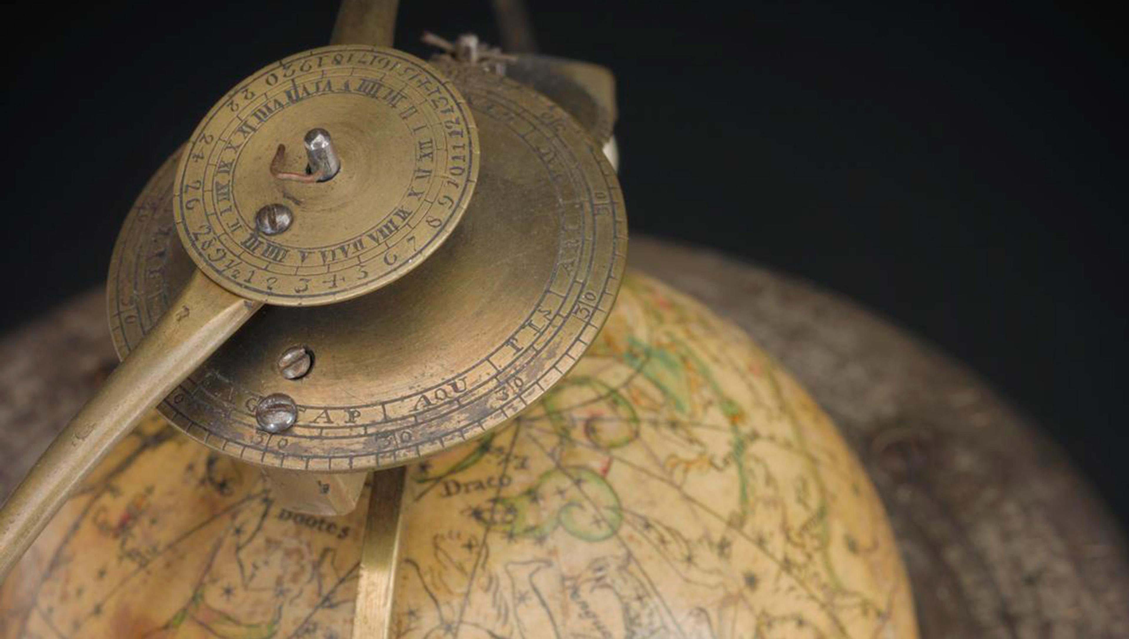 A rotating antique globe in brass and other materials seen from above