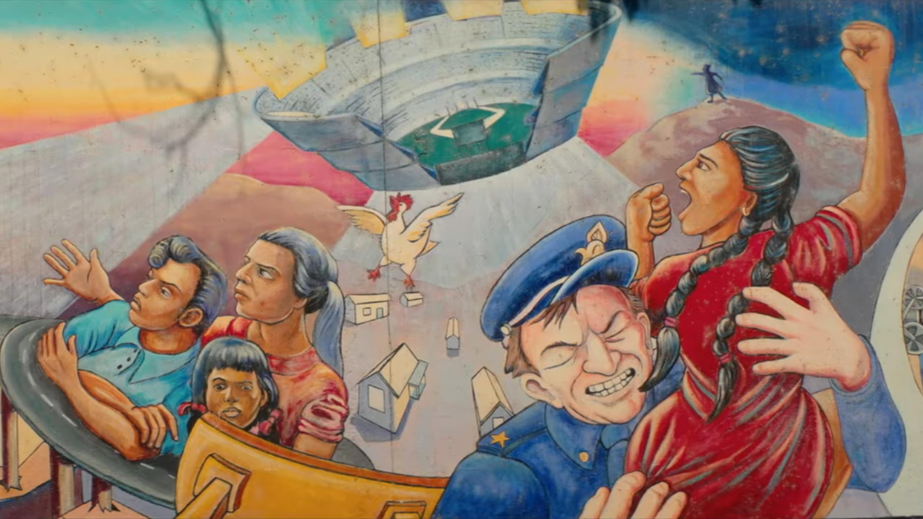 A colourful mural depicting a Mexican American family, a Mexican American woman being tackled by a white policeman, and a stadium resembling a U F O descending from the sky.