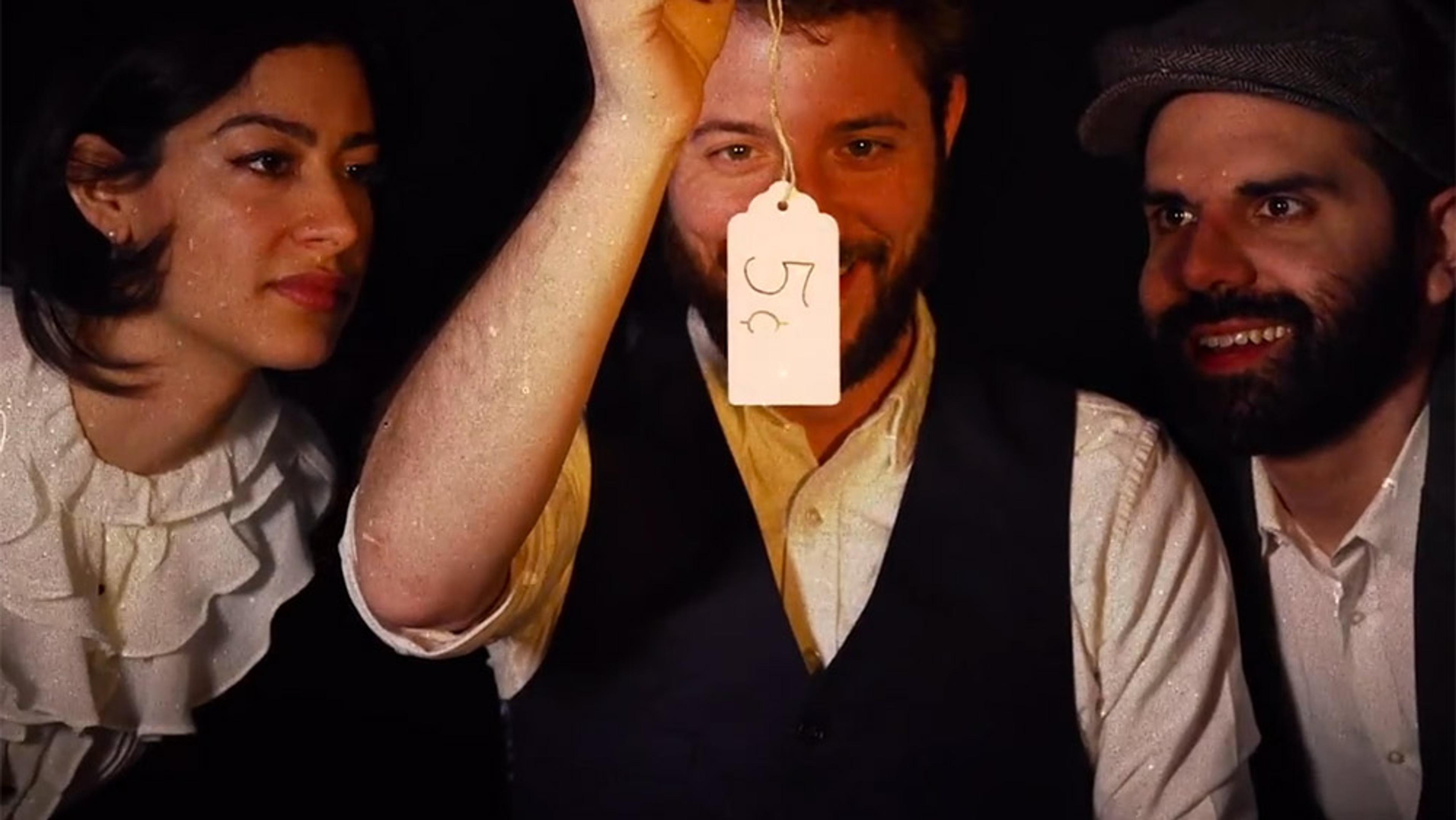 Two men and a woman looking at a price tag with “5¢” written on it; one man is holding up the tag.