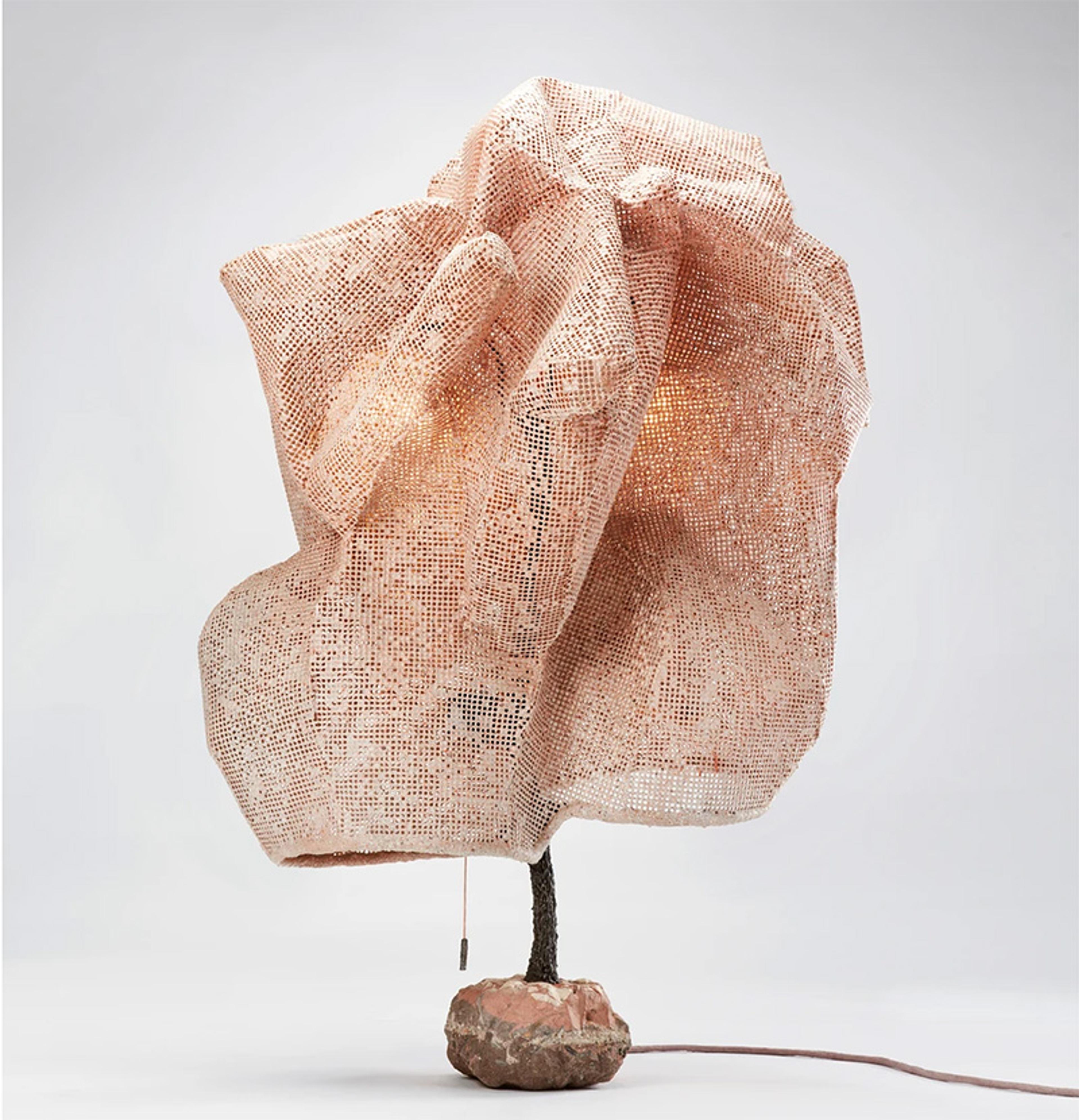 A table lamp with a crinkled fabric shade, mounted on a stone base, against a white background.