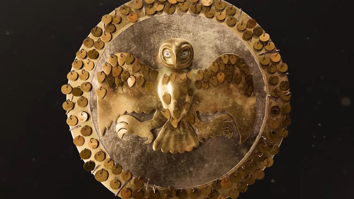 金色金属艺术品，带有猫头鹰图案，周围环绕着深色背景上的装饰圆盘。