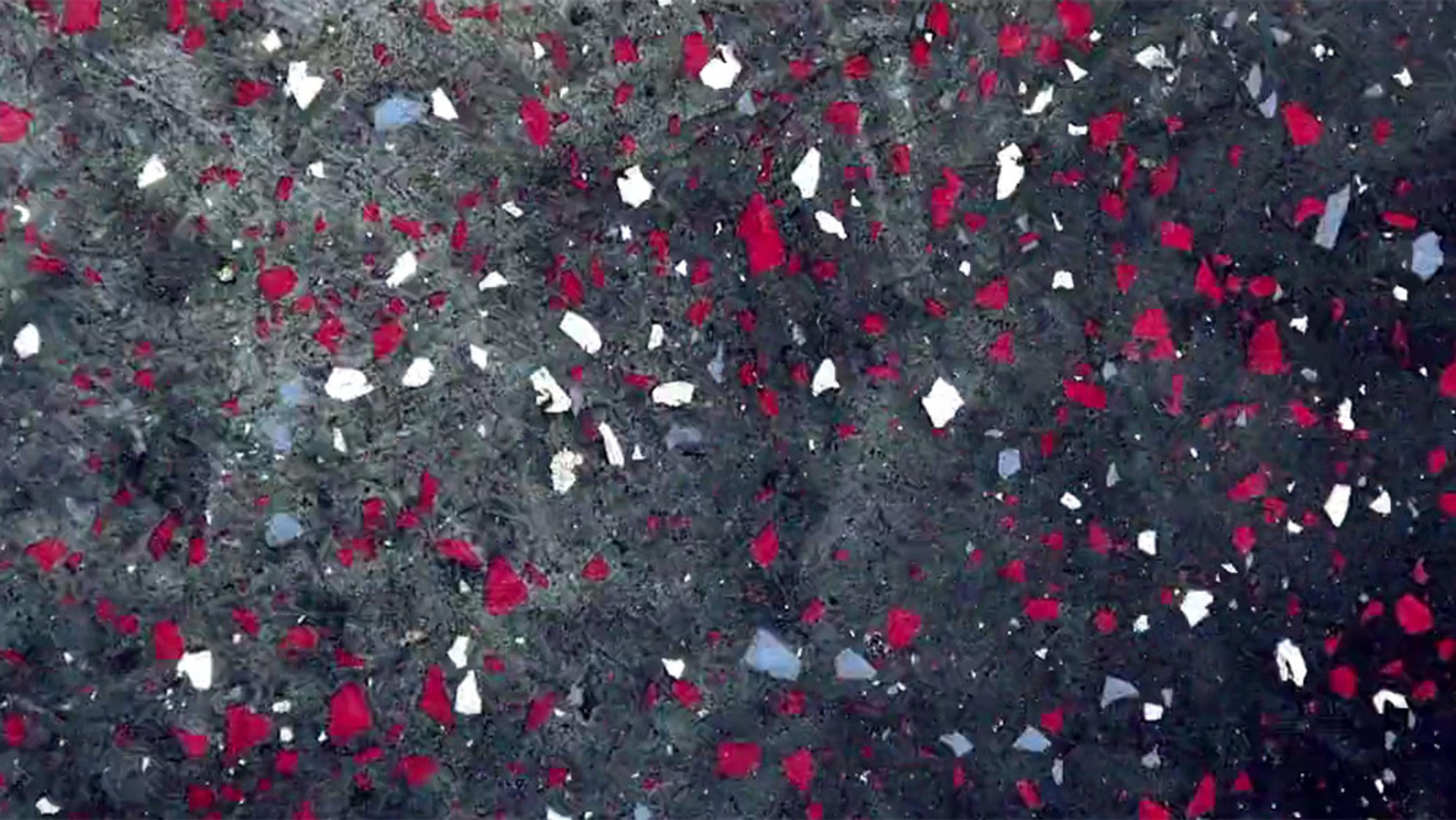 Abstract painting with a dark background featuring scattered red, white and grey fragments. The texture appears rough.