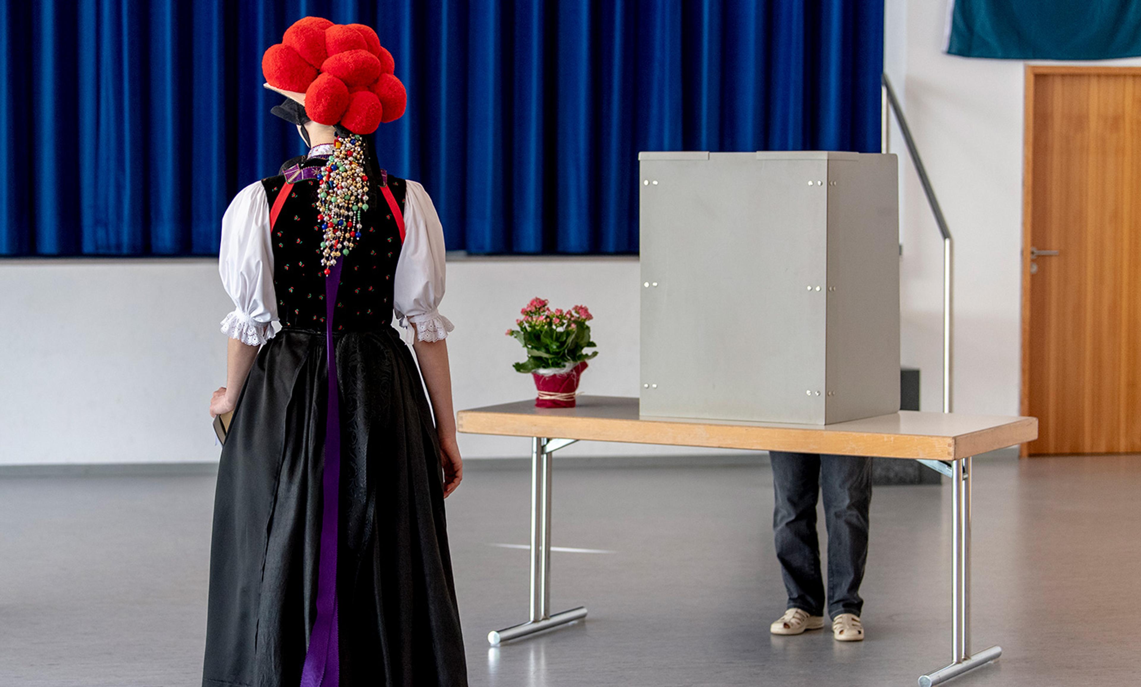 <p>A voter in traditional Black Forest costume at the polling station during the European elections. Baden-Württemberg, Germany, May 2019. <em>Photo by Patrick Seeger/Dpa/Getty</em></p>