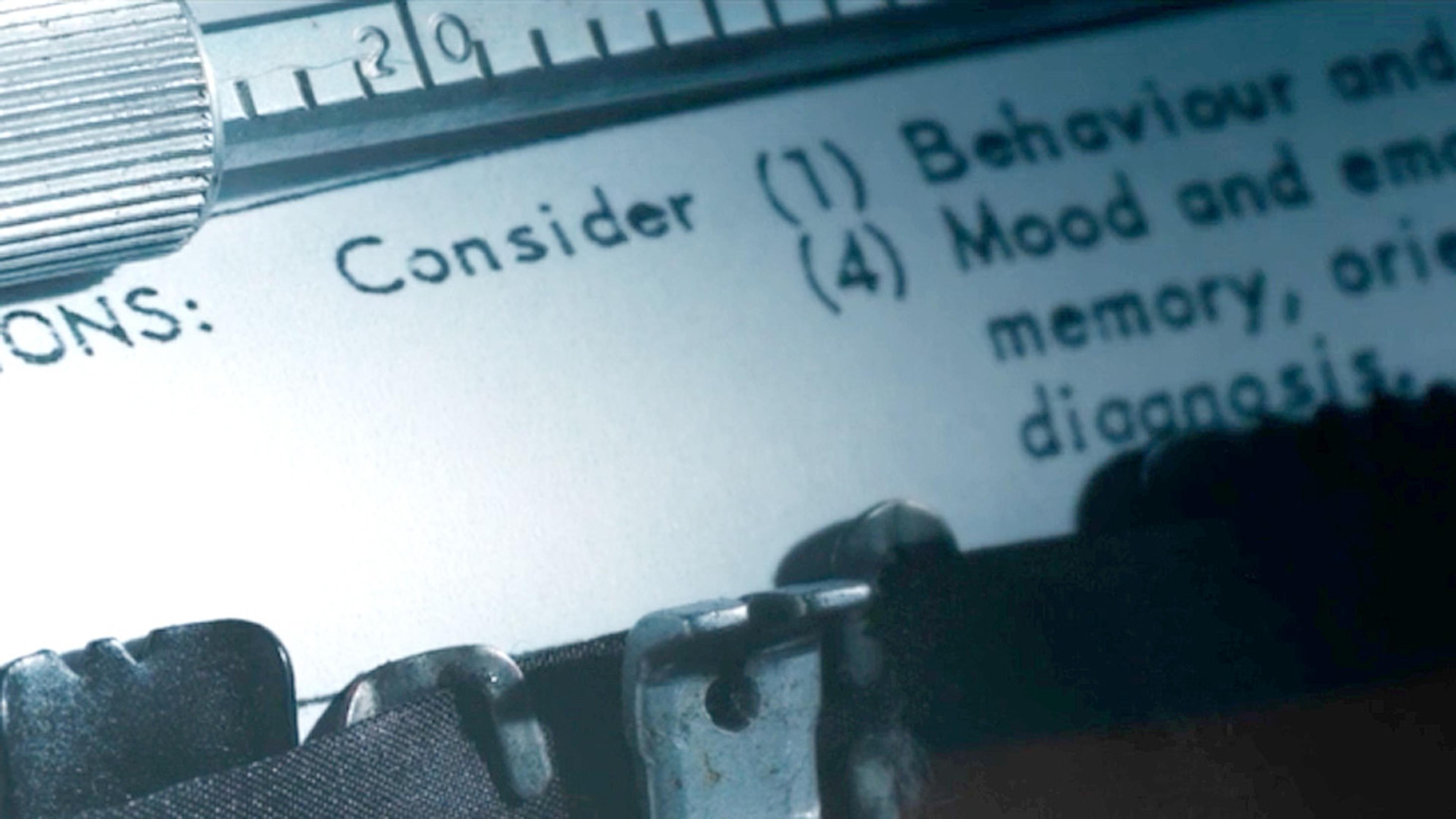 Close-up of a typewriter typing a document with the word ‘Consider’ visible and a metal ruler in the top left.