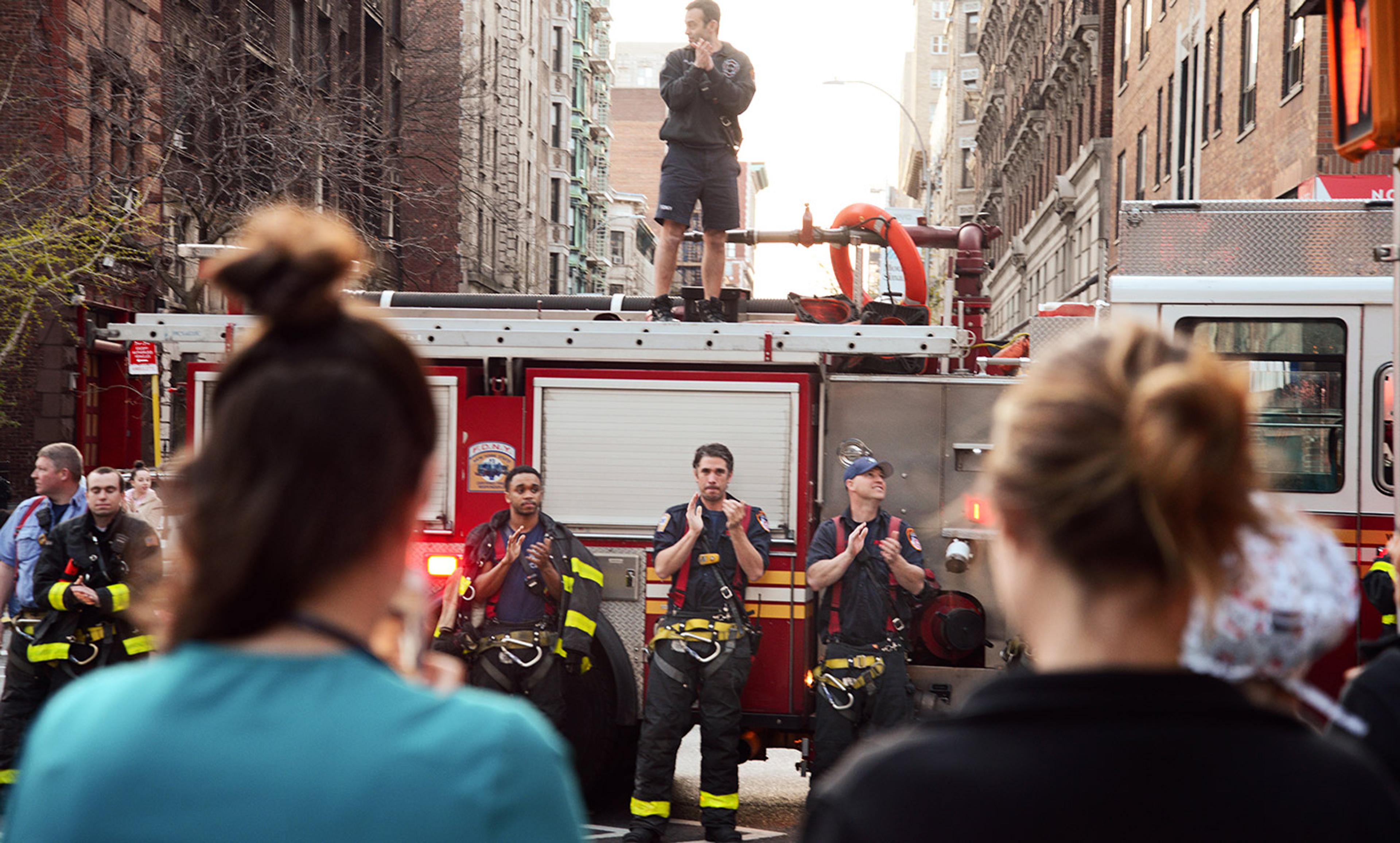 <p>Firefighters applaud medical workers in Manhattan, New York, on 7 April 2020. <em>Photo B A Van Sise/NurPhoto via Getty</em></p>
