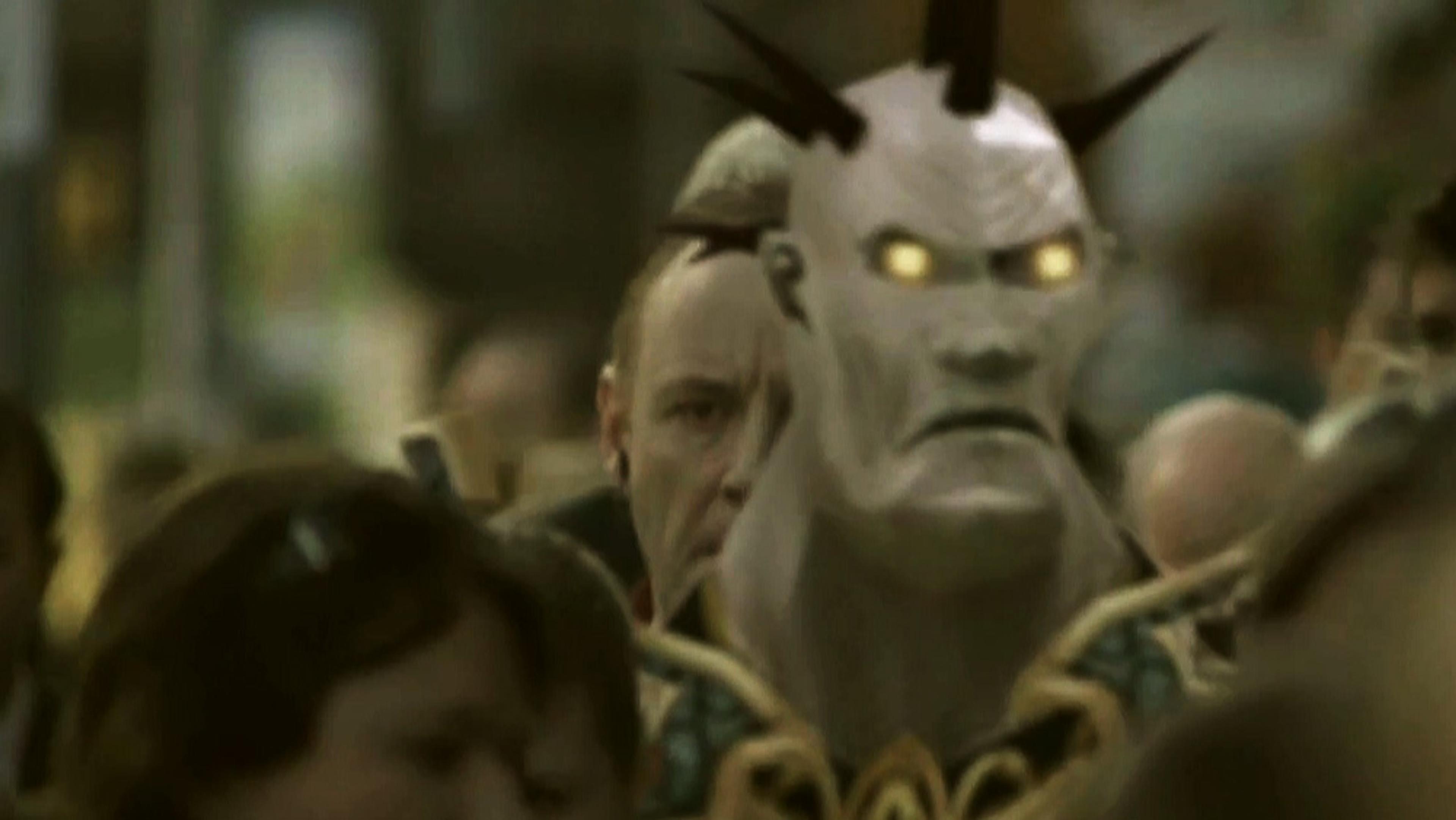 A CGI character with horns and glowing eyes stands among a crowd of people.