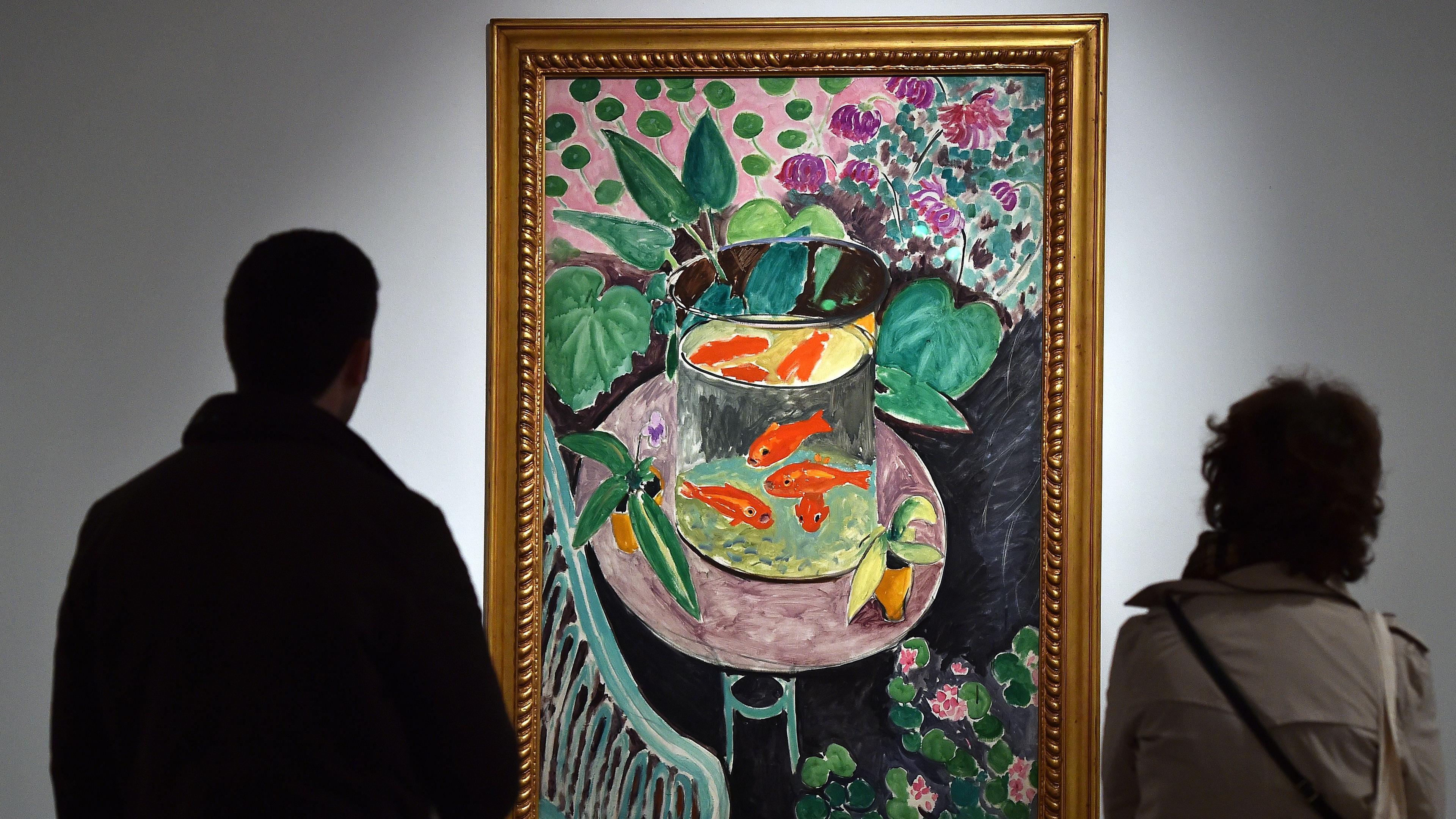 Painting of goldfish in a bowl surrounded by plants with two people viewing in a gallery setting.