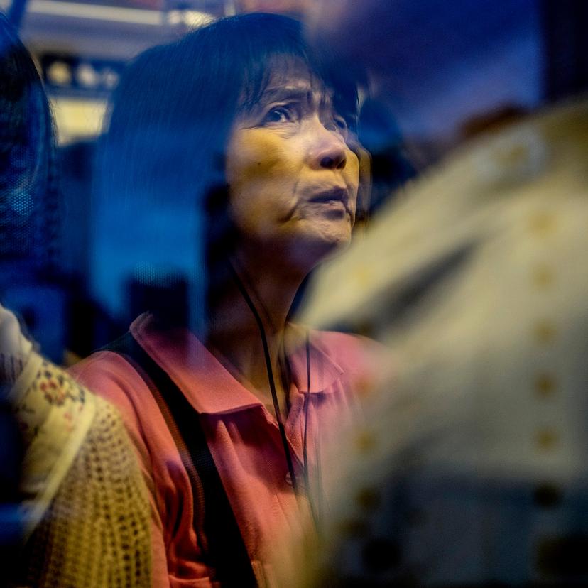 A woman looking anxious on a subway train