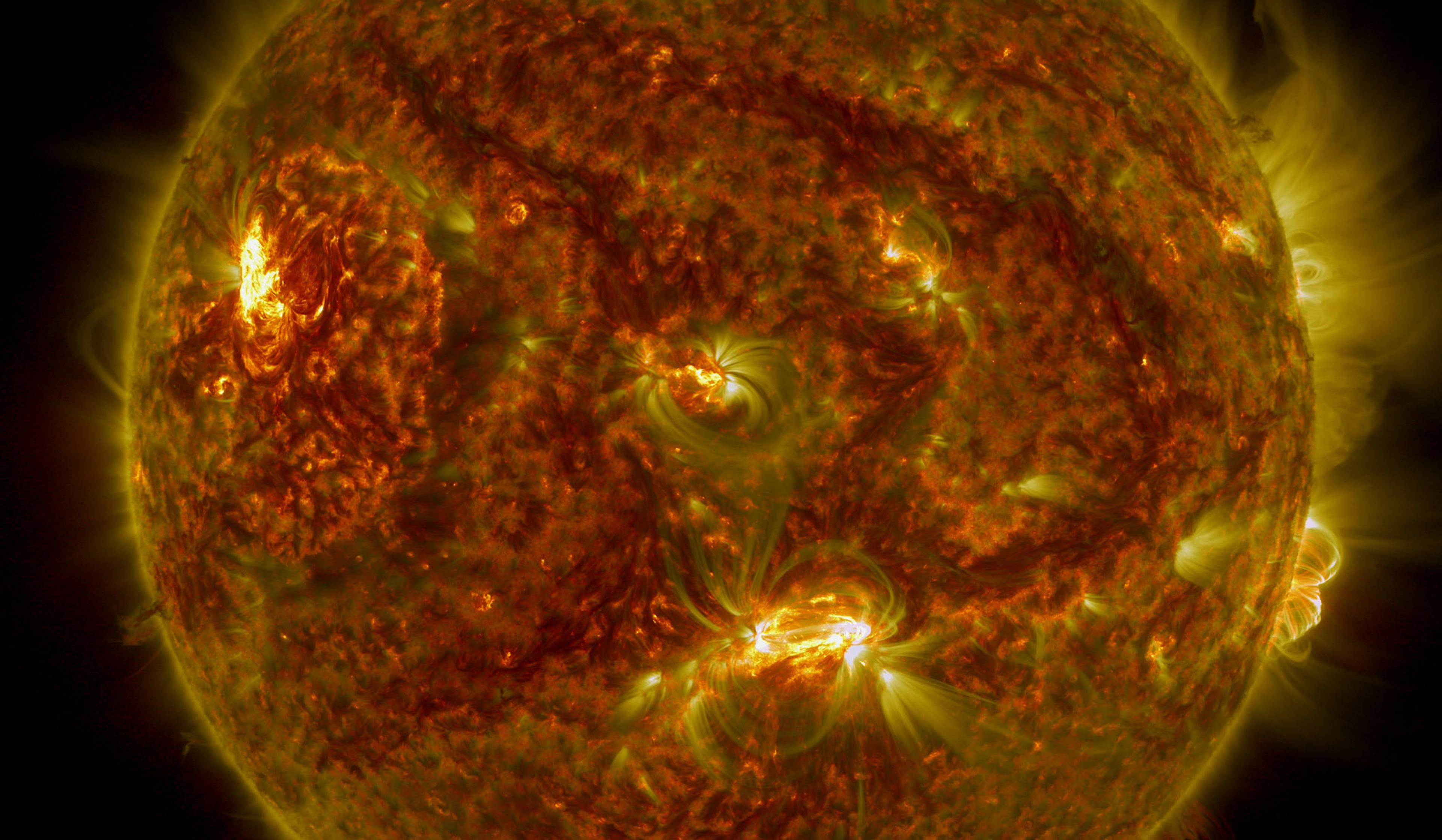 Close-up of the Sun’s surface with visible solar flares and sunspots, captured in vibrant red and yellow hues.