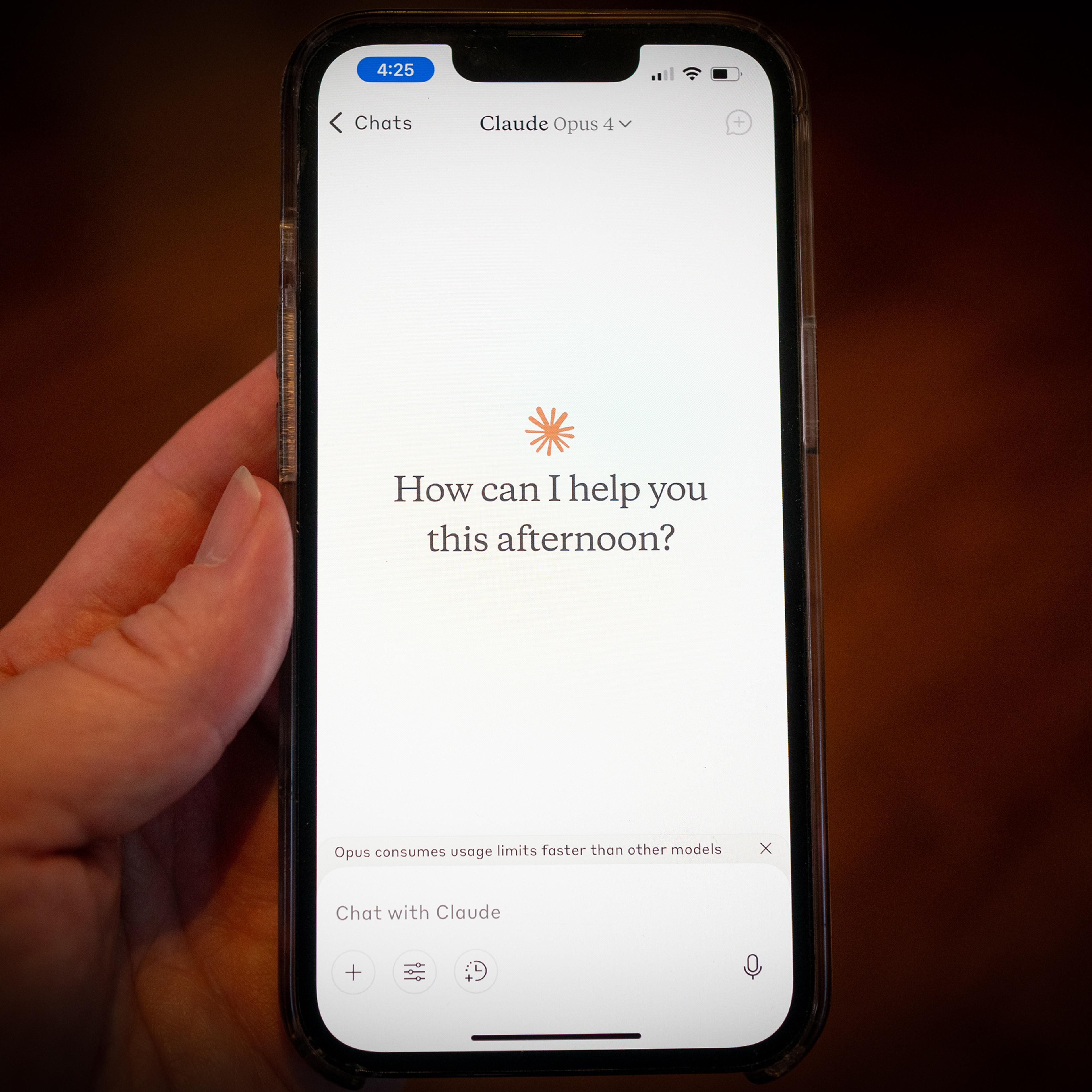 عکس دستی که گوشی هوشمند را در دست دارد و رابط برنامه چت را نشان میدهد؛ پرسش «امروز بعد از ظهر چطور میتوانم کمکتان کنم؟»