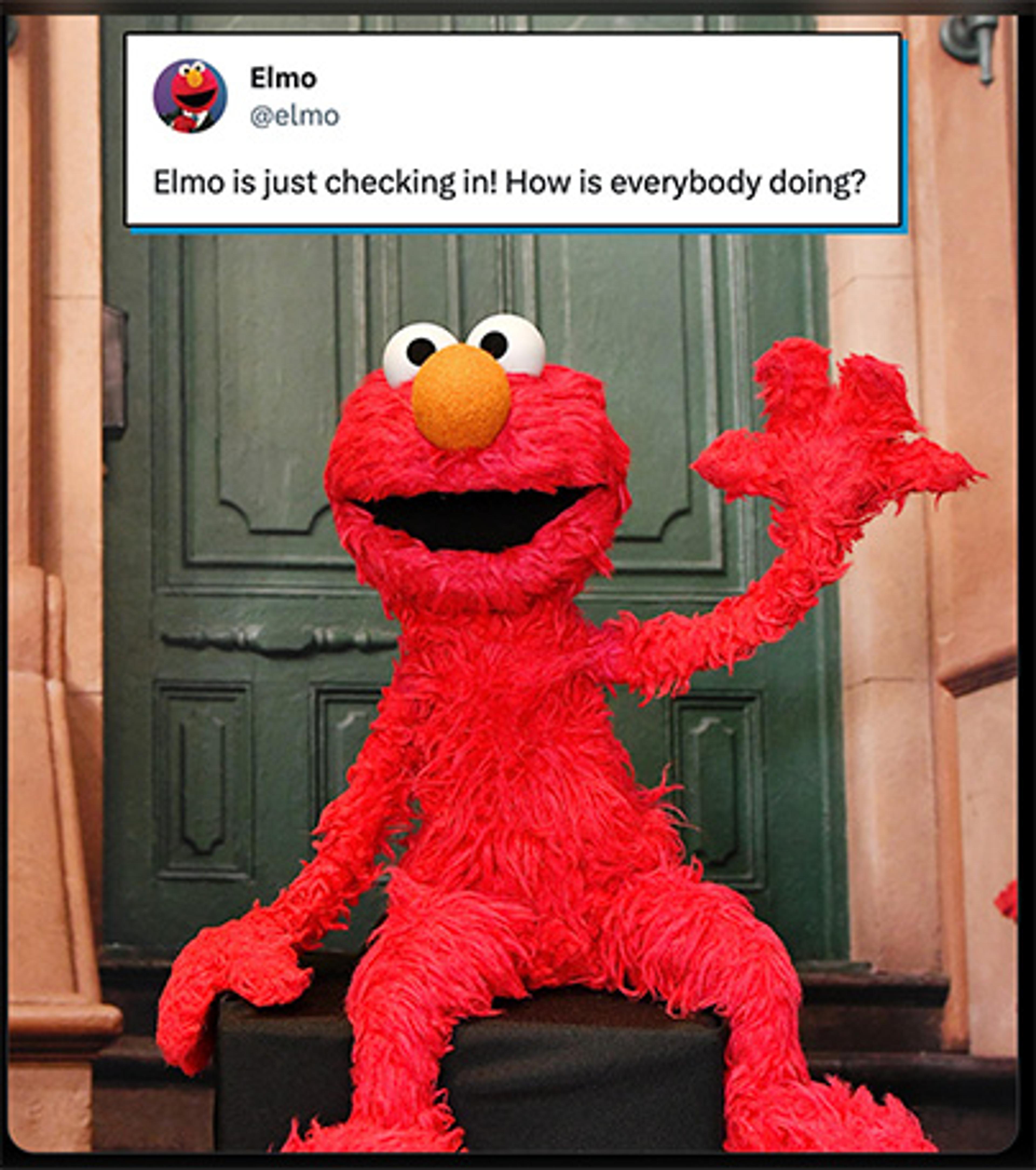 Photo of Elmo puppet waving on steps with a Tweet saying “Elmo is just checking in! How is everybody doing?”