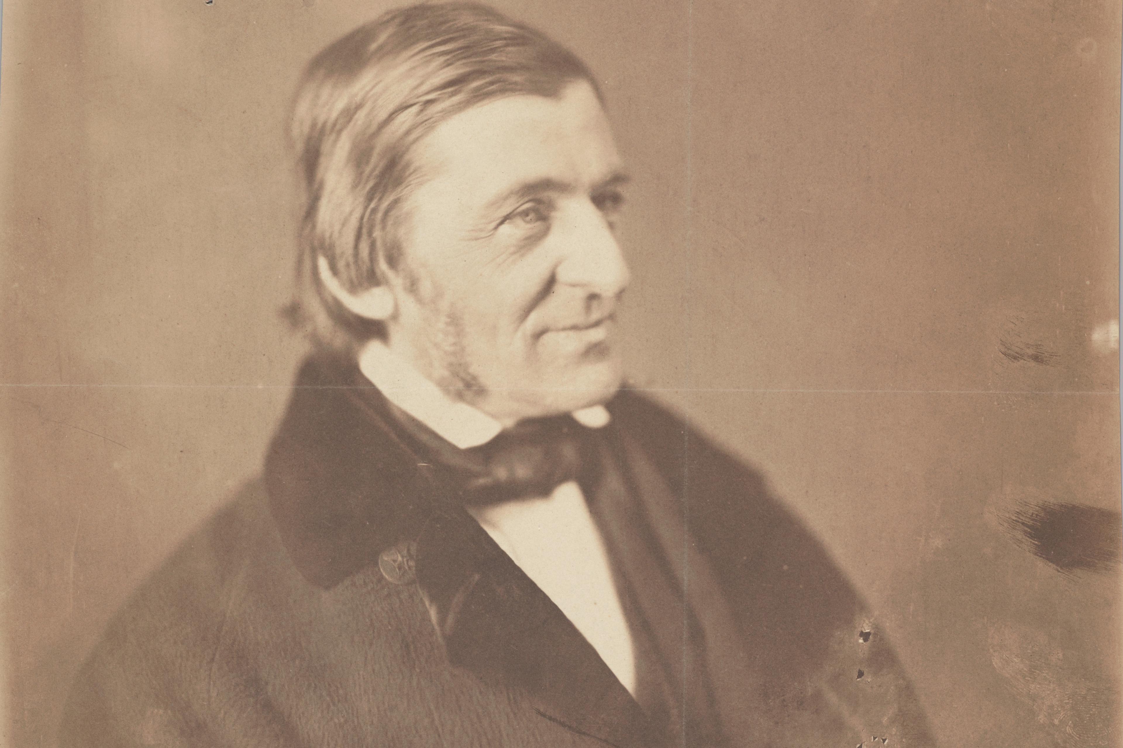 Vintage sepia photograph of a man in a suit looking to the right with a pensive expression and slightly damaged background.