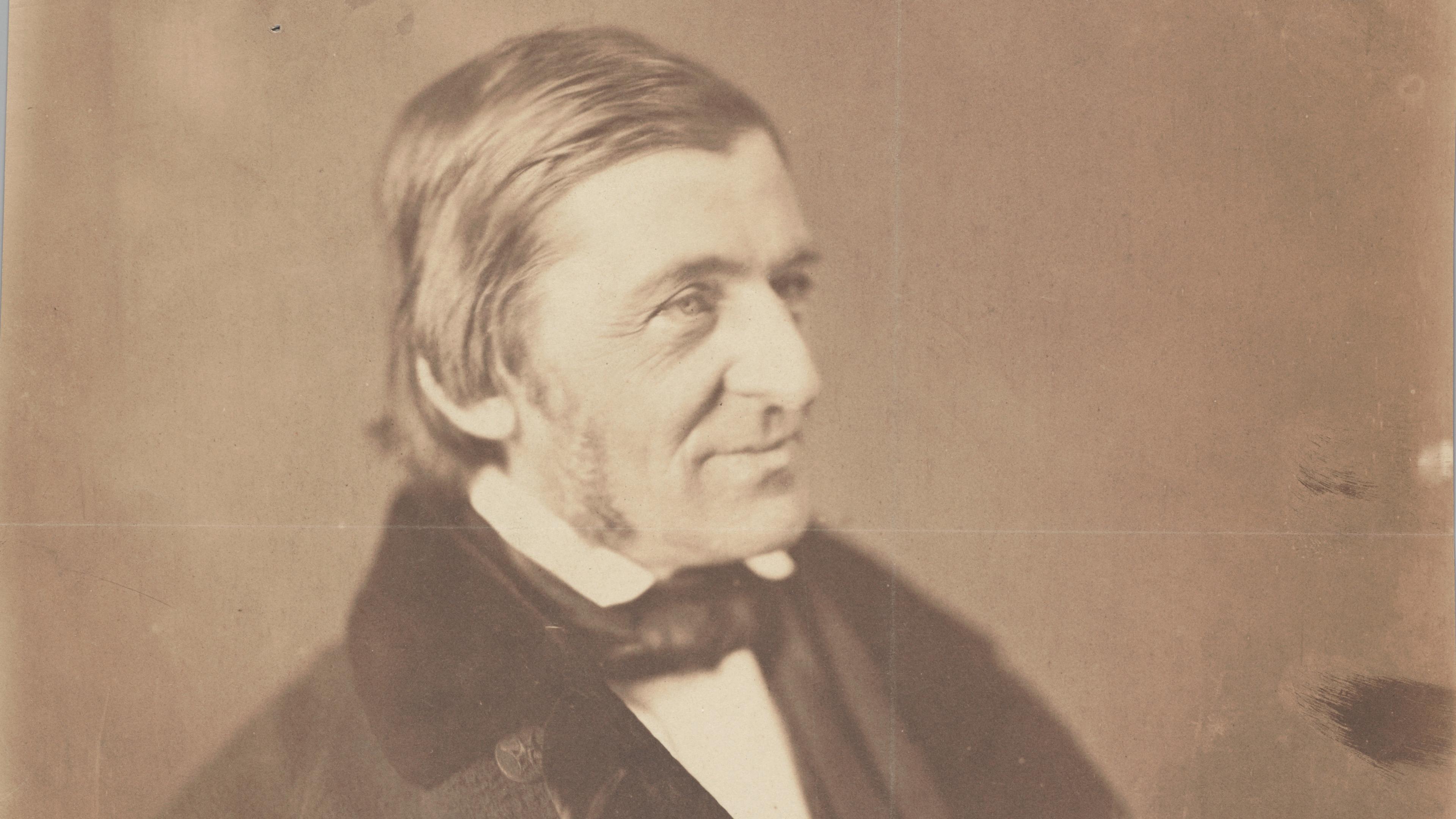 Vintage sepia photograph of a man in a suit looking to the right with a pensive expression and slightly damaged background.