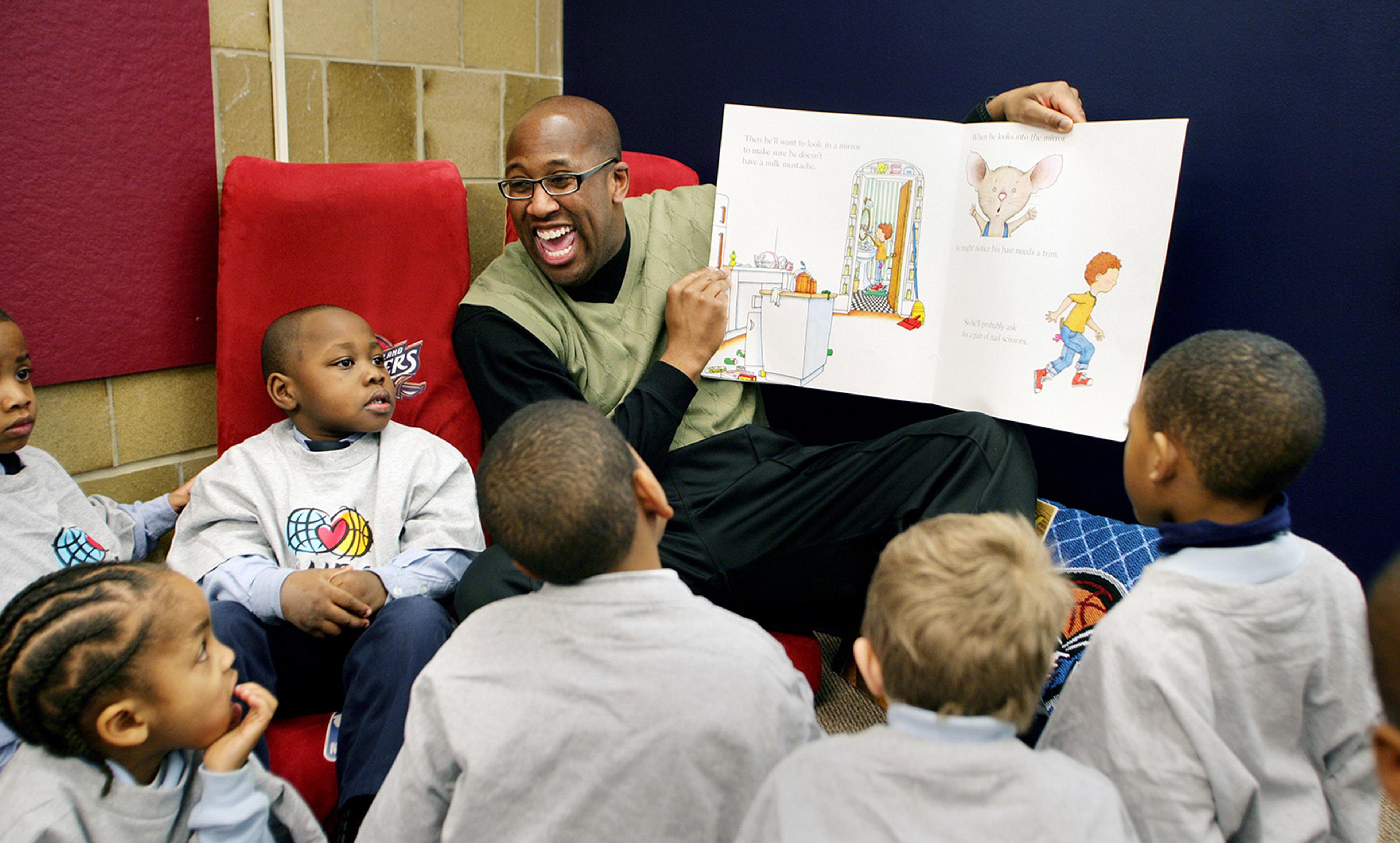 <p>Mike Brown, former head coach of the Cleveland Cavaliers, reads to children at the Cavaliers All-Star Library at the Kenneth Clement Boys Leadership Academy, 12 February 2008. <em>Photo by David Liam Kyle/Getty</em></p>