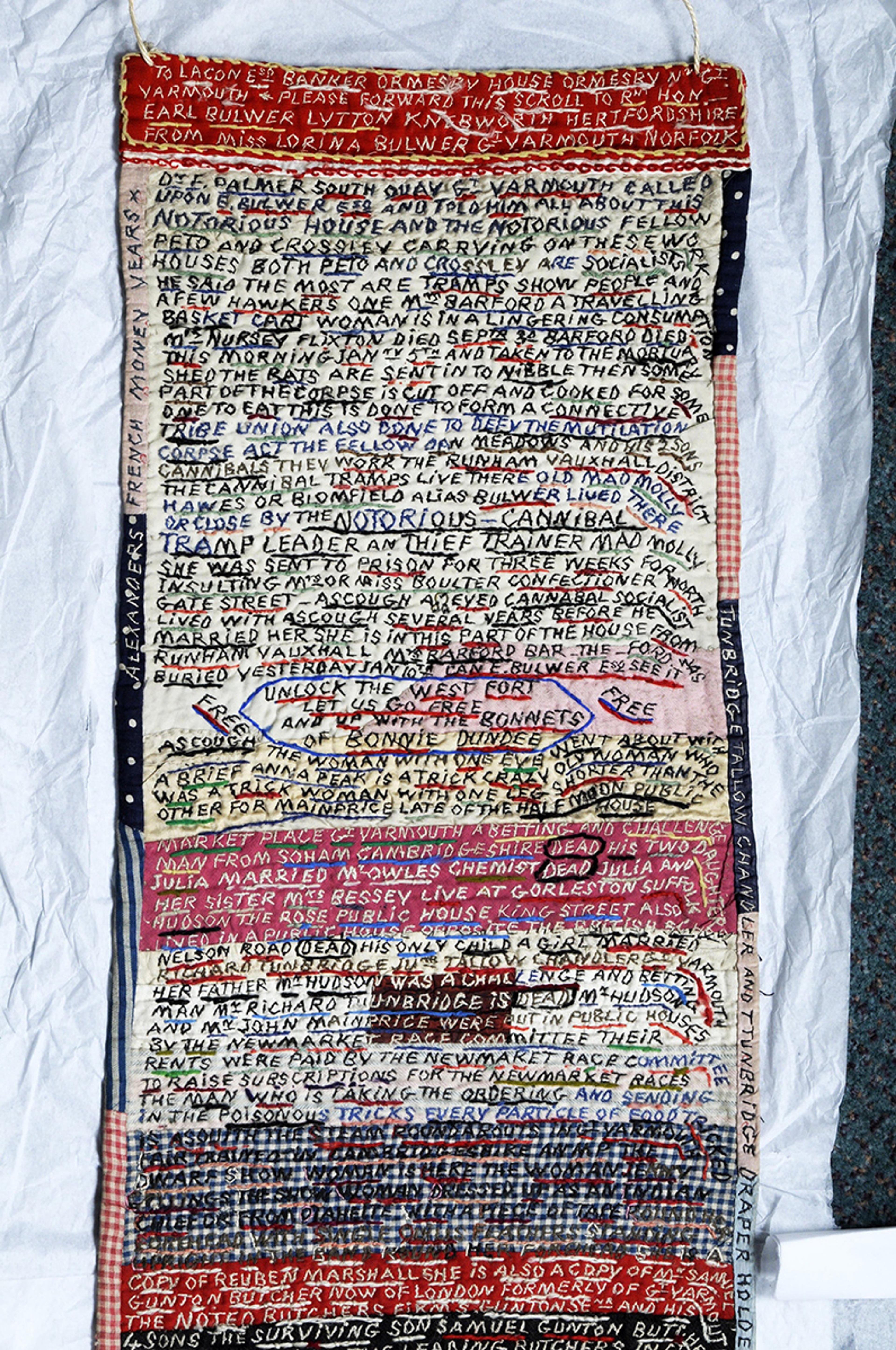 Hand-embroidered textile with dense text in various colours.