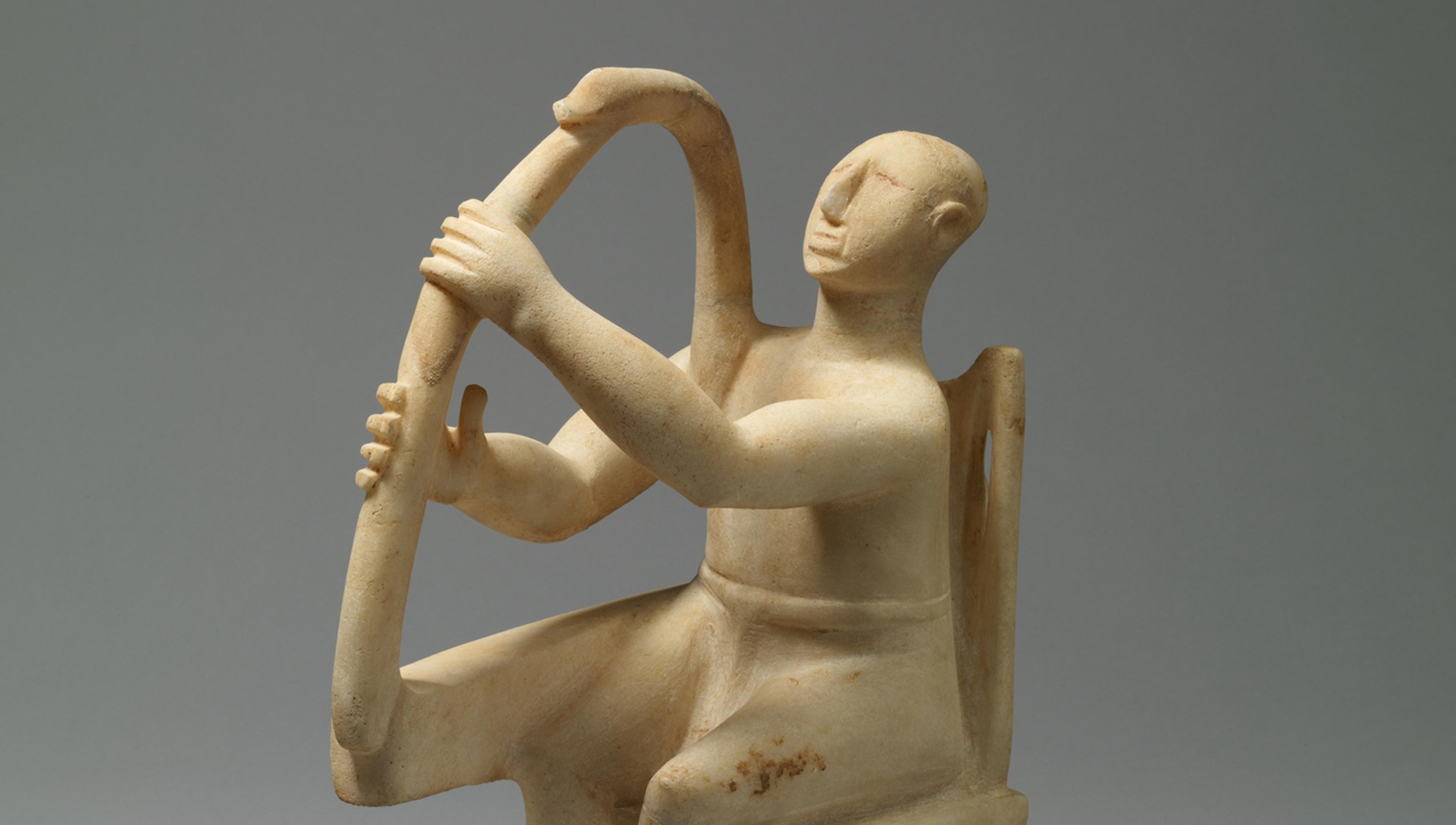 A marble figurine seated in a chair plays a harp