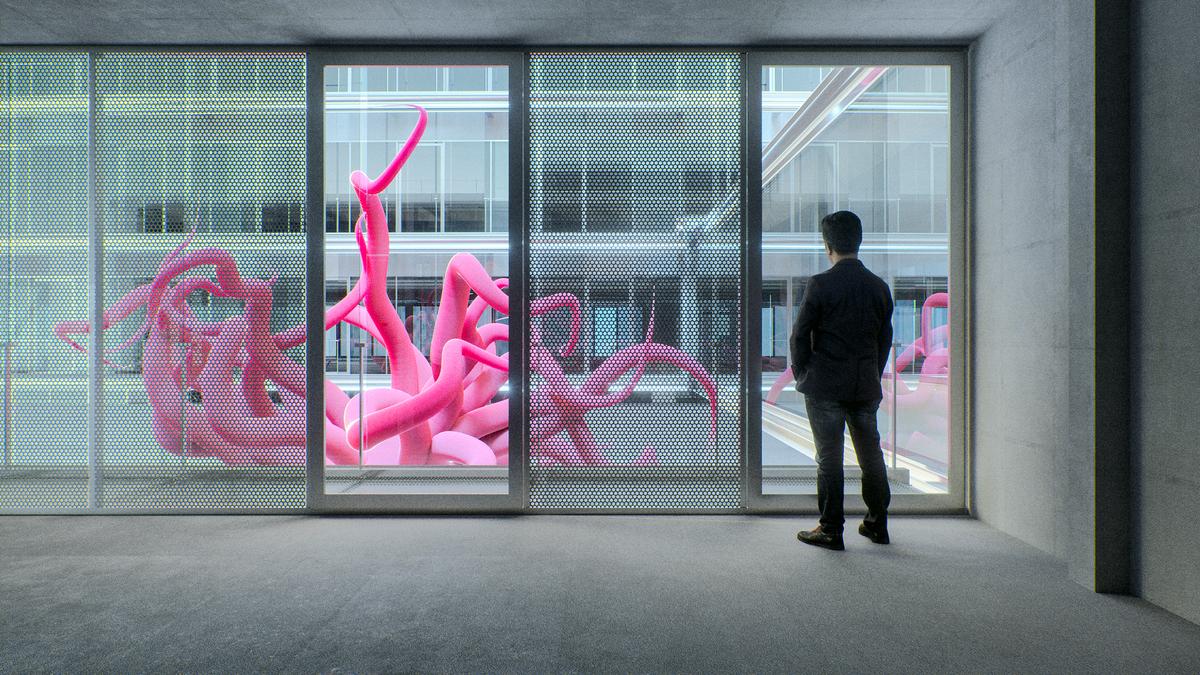 A man stands in a modern room looking at a large pink sculpture of tentacles outside the window.
