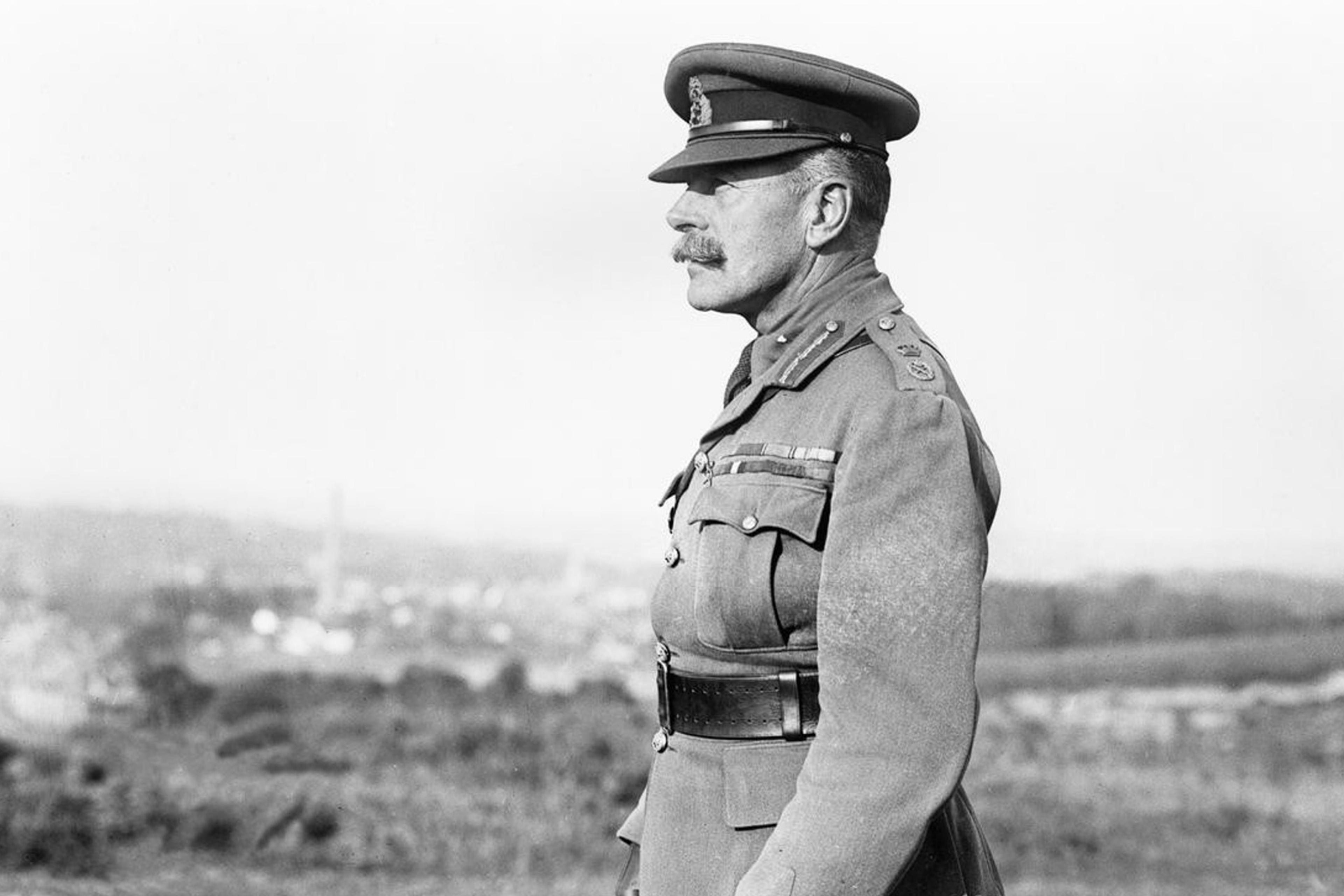 Black and white photo of a military officer in profile wearing a uniform and cap against a blurred landscape background.