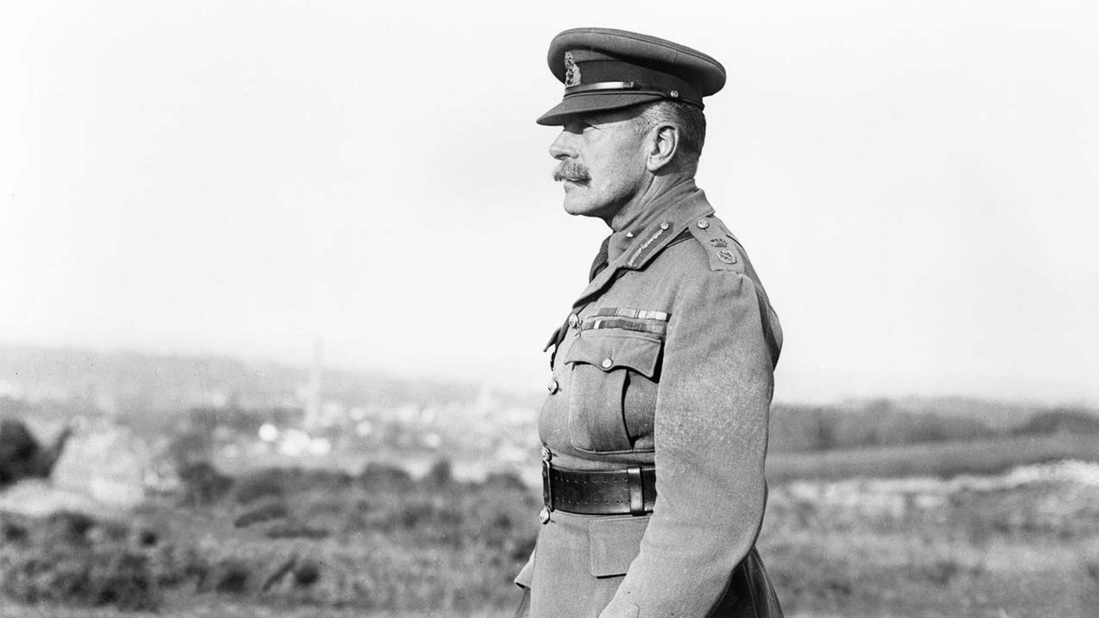Black and white photo of a military officer in profile wearing a uniform and cap against a blurred landscape background.