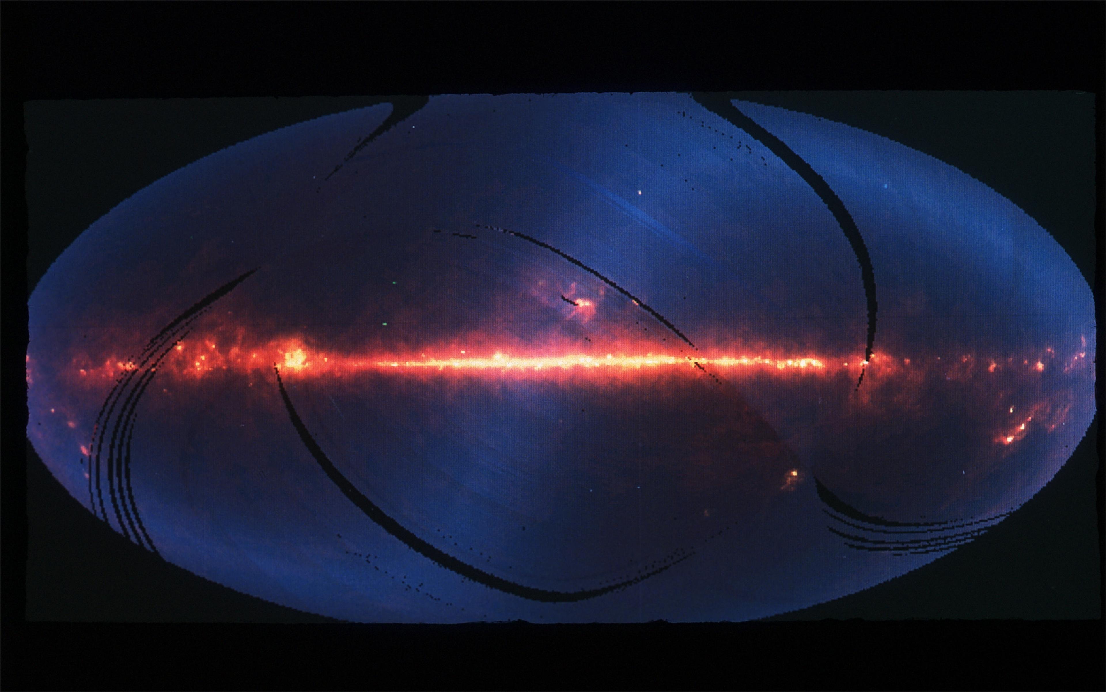 Infrared image of the Milky Way shows a glowing red band of stars across a blue background, indicating cosmic dust and gas.