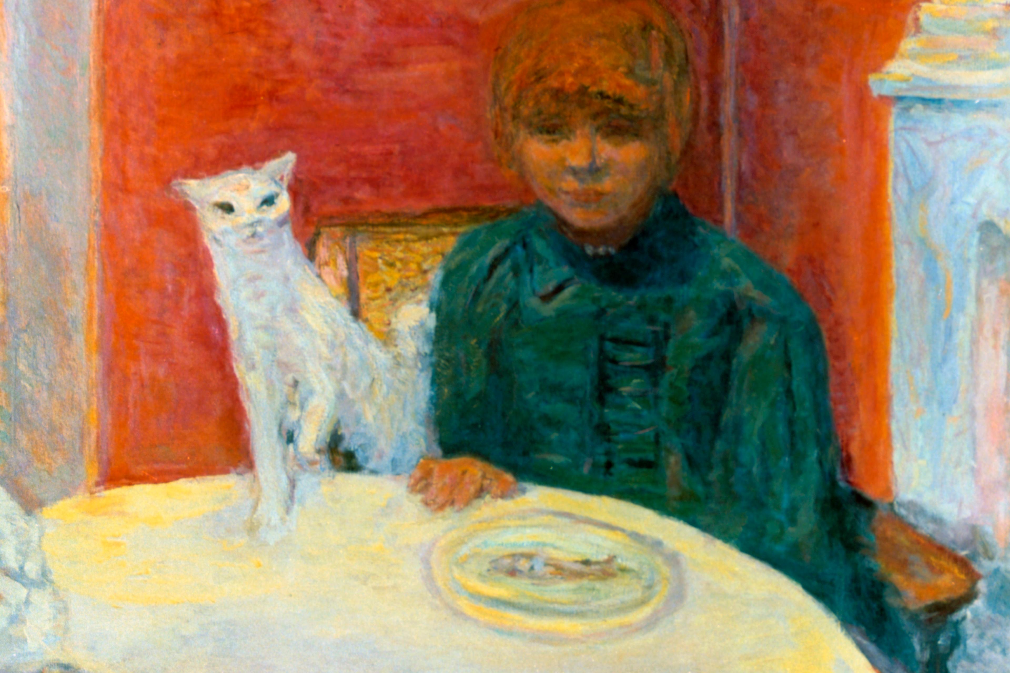 Painting of a child seated at a table with a white cat on a red background. A bowl of fruit is in the foreground.