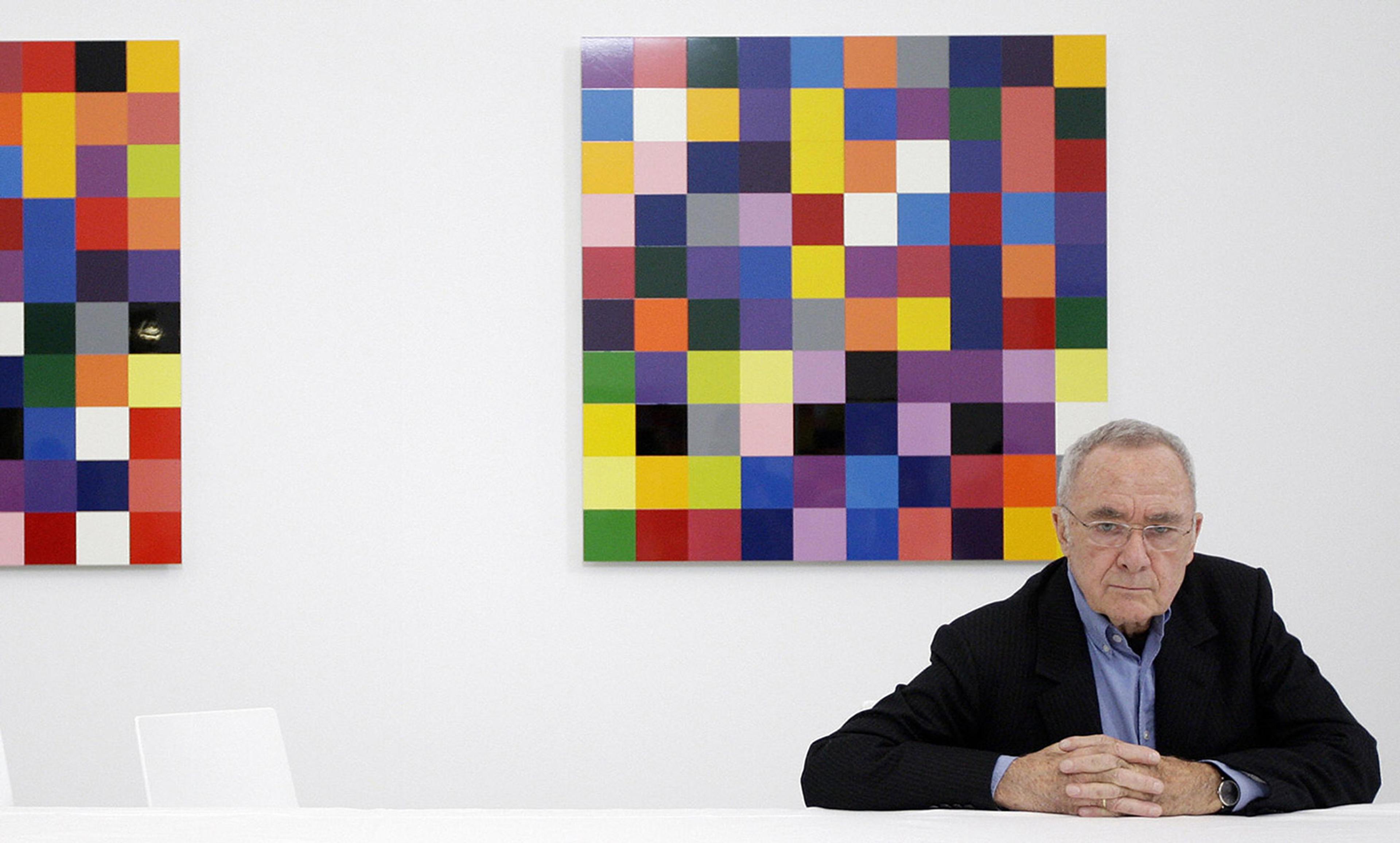 <p>The German artist Gerhard Richter with a panel from his <em>4900 Colours</em> (2008) at the Serpentine Gallery in London. The seemingly arbitrary distribution of colours was generated using a specially developed computer program. <em>Photo by Shaun Curry/Getty</em></p>