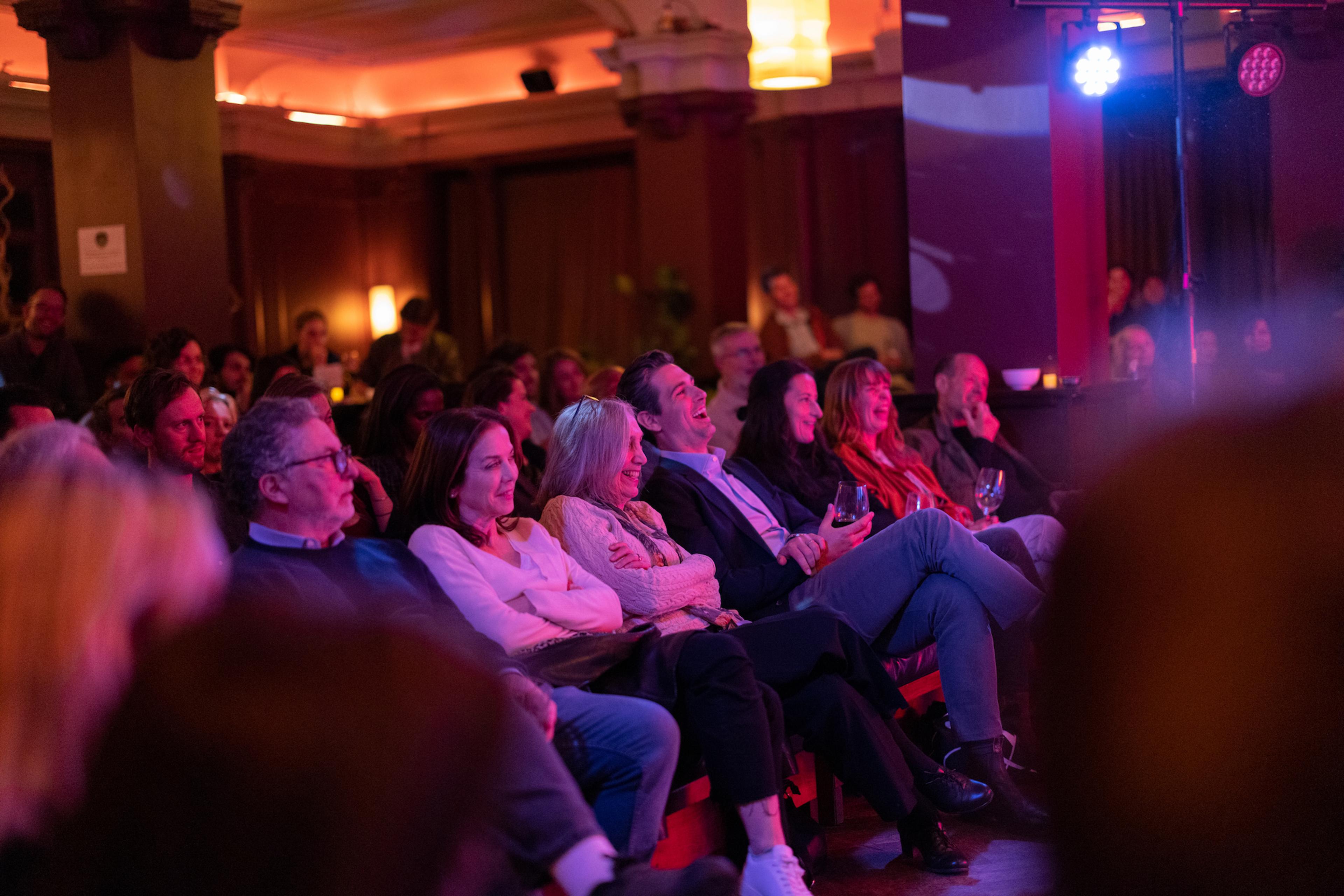 The audience looking towards the stage laughing