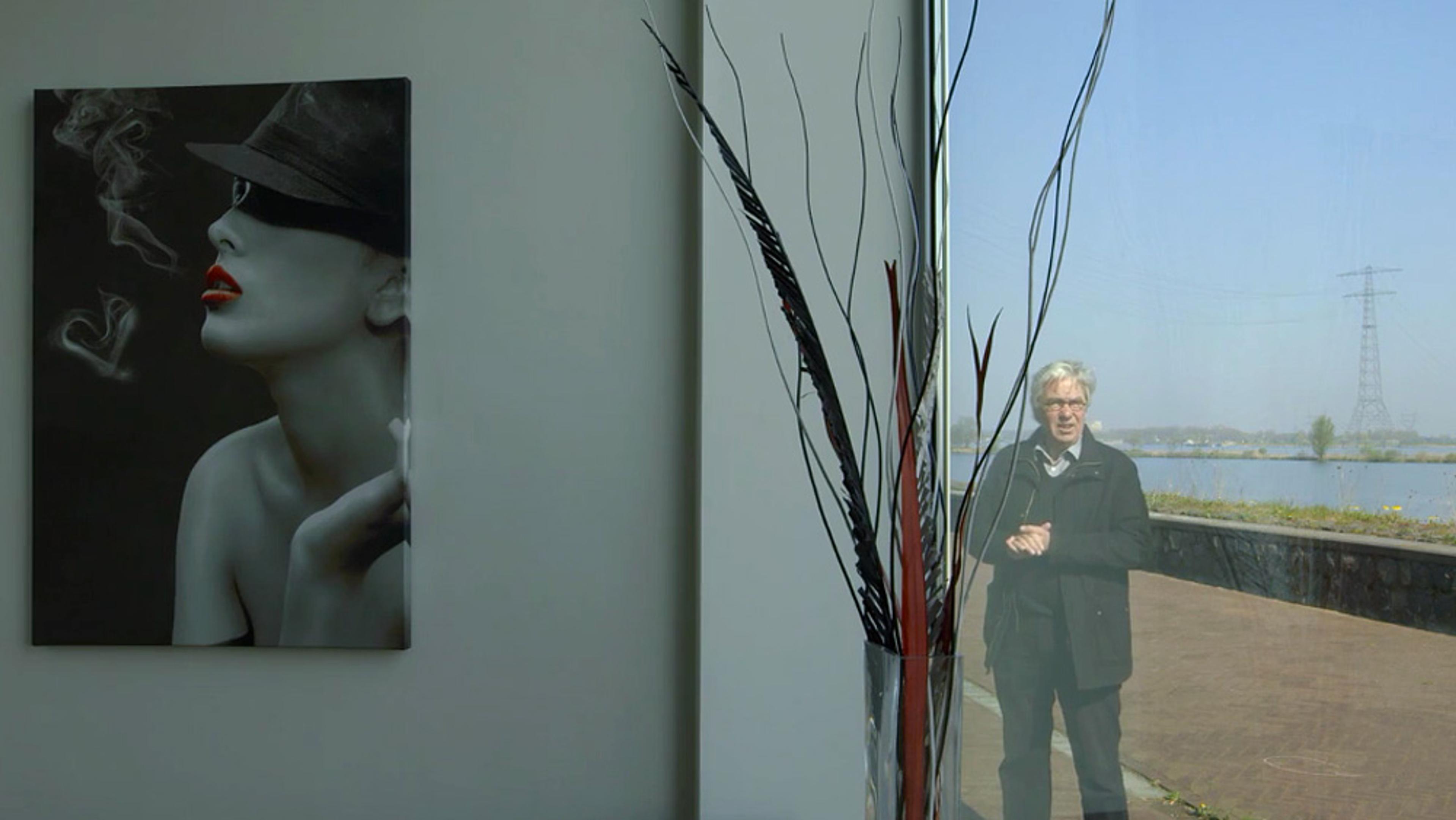 A stylish painting of a woman smoking indoors, a man outside reflected in a window, and tall decorative branches in a vase.