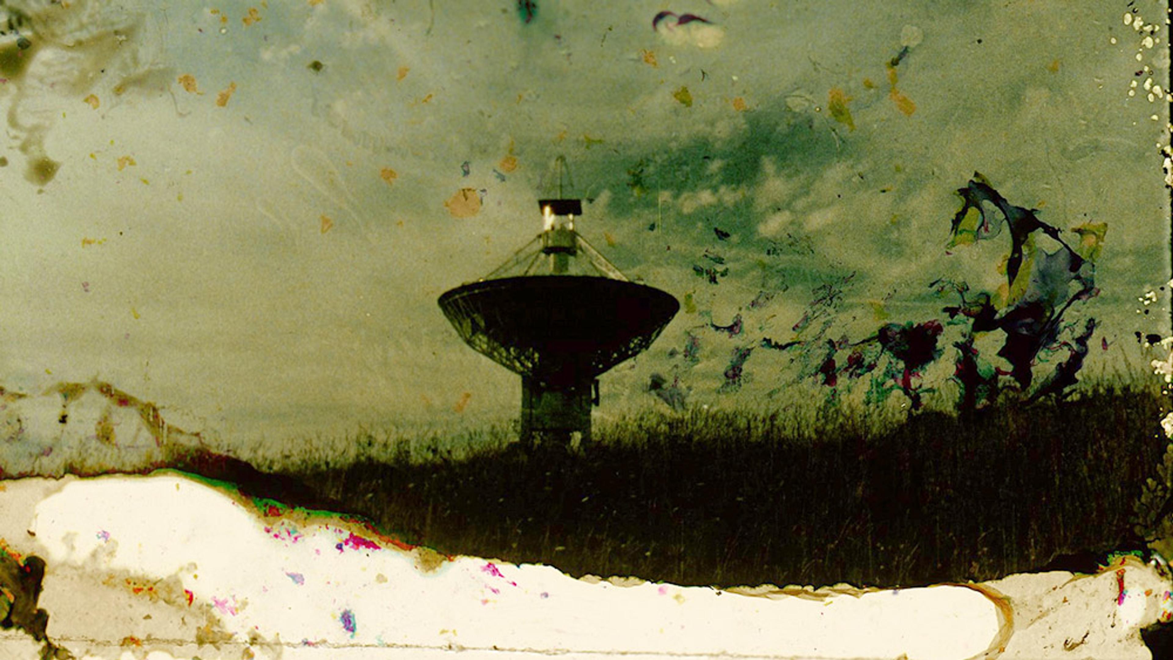 A large radio telescope dish against a cloudy sky, with heavy staining and damage across the image.