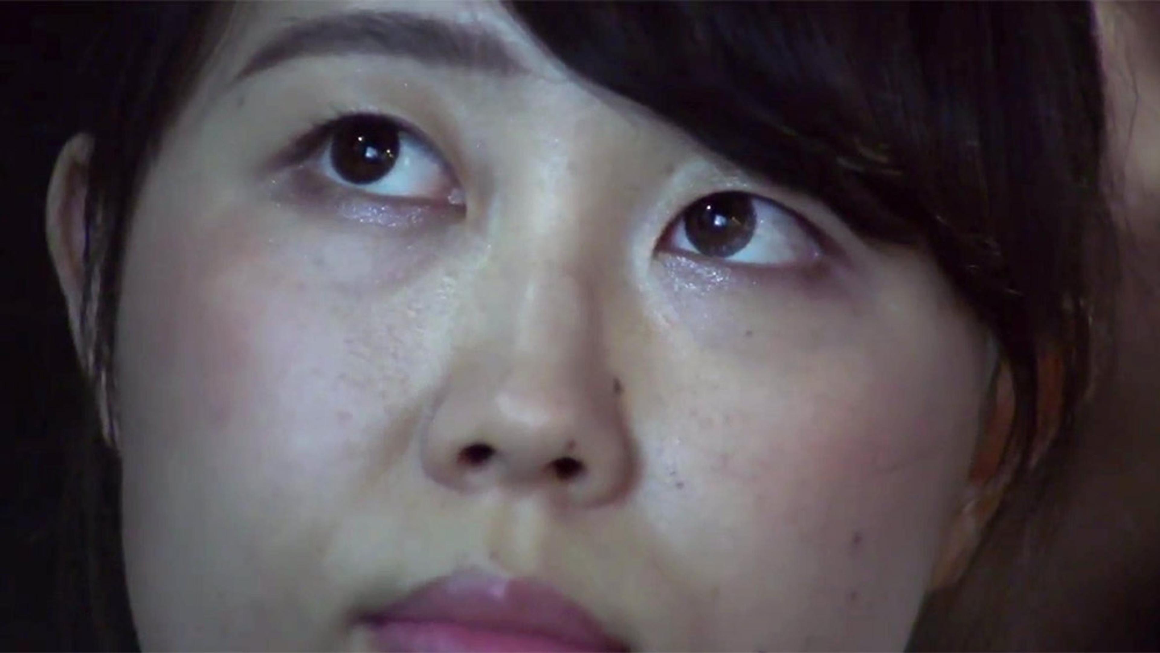 Close-up of a woman’s face showing her eyes looking upward with concern.