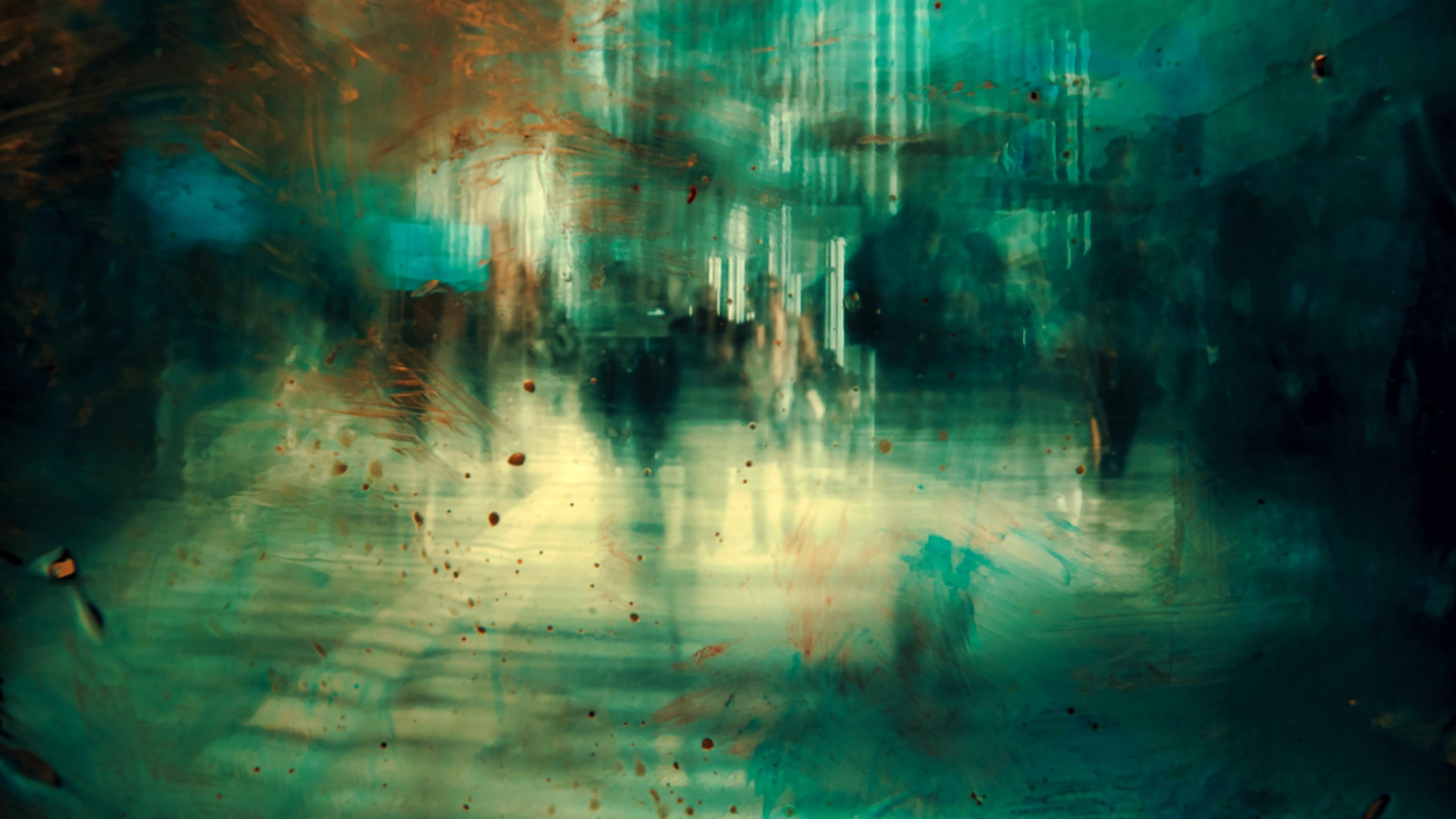 Abstract painting of a blurred urban scene with teal and orange hues depicting moving silhouettes in a cityscape.