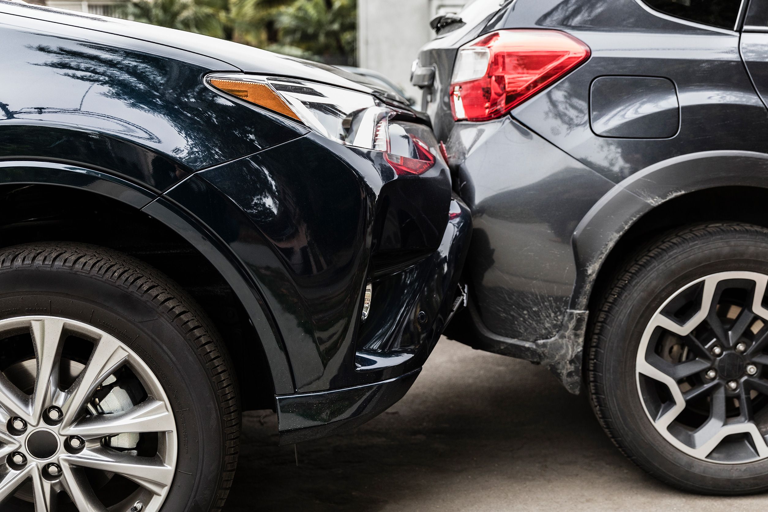 A rear-end collision between two cars, showing damage and close details of tyres and bumpers.
