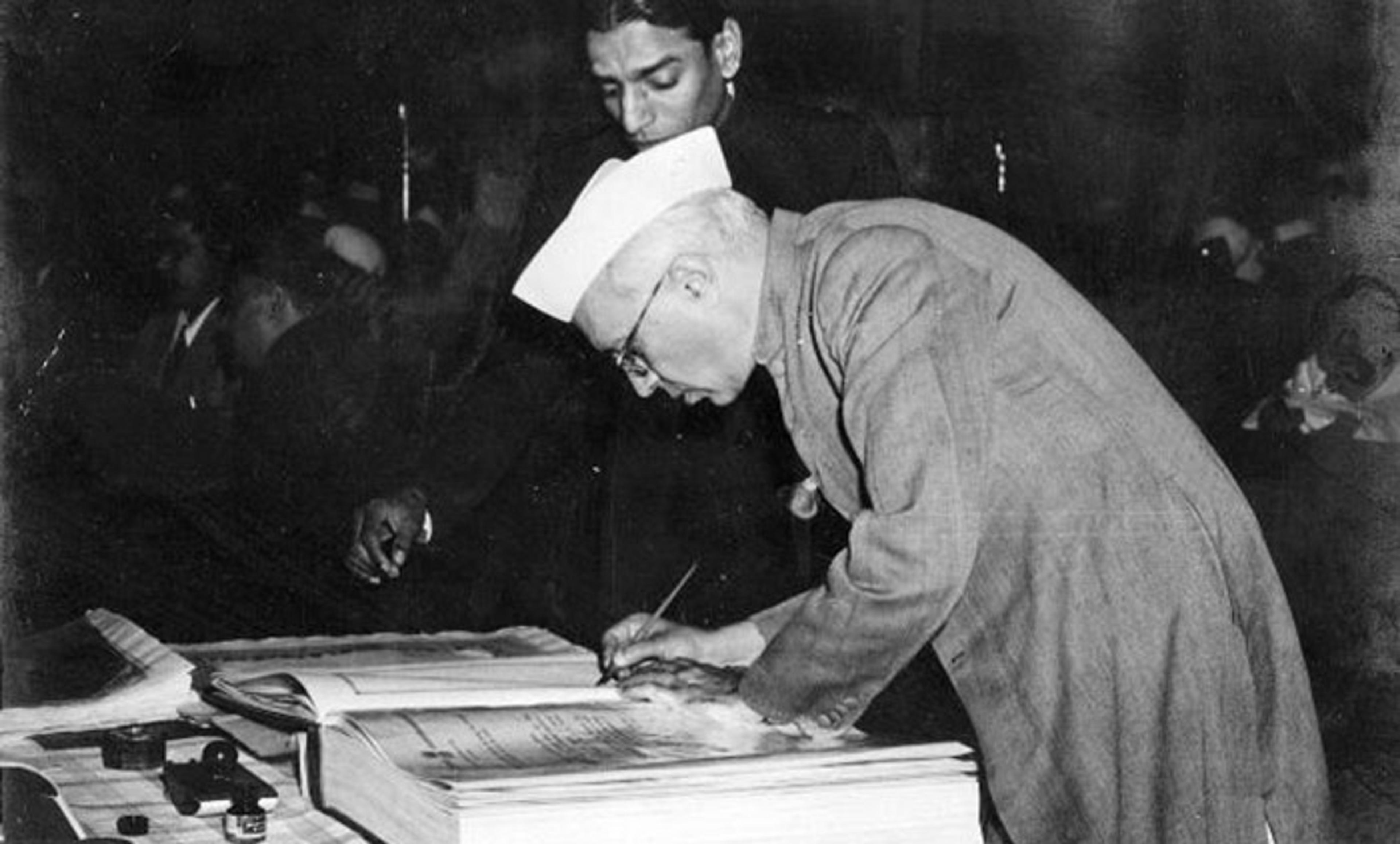 <p>Jawaharlal Nehru signing the Indian Constitution in 1950. <em>Courtesy Wikimedia</em></p>