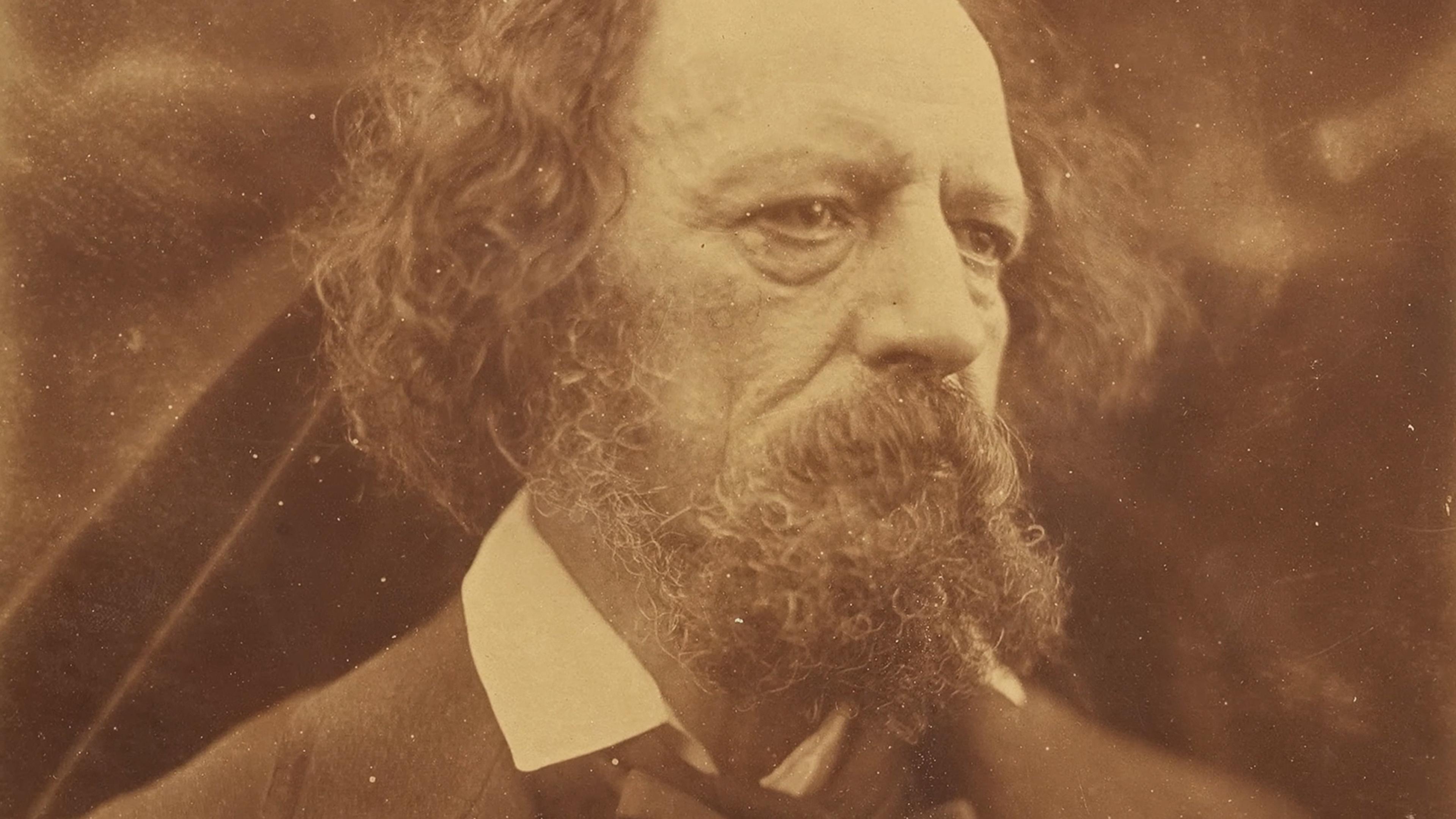 Sepia photograph of an older man with long curly hair and a full beard and moustache, wearing a white shirt with a dark suit. His expression appears thoughtful, and he is looking slightly to his right.